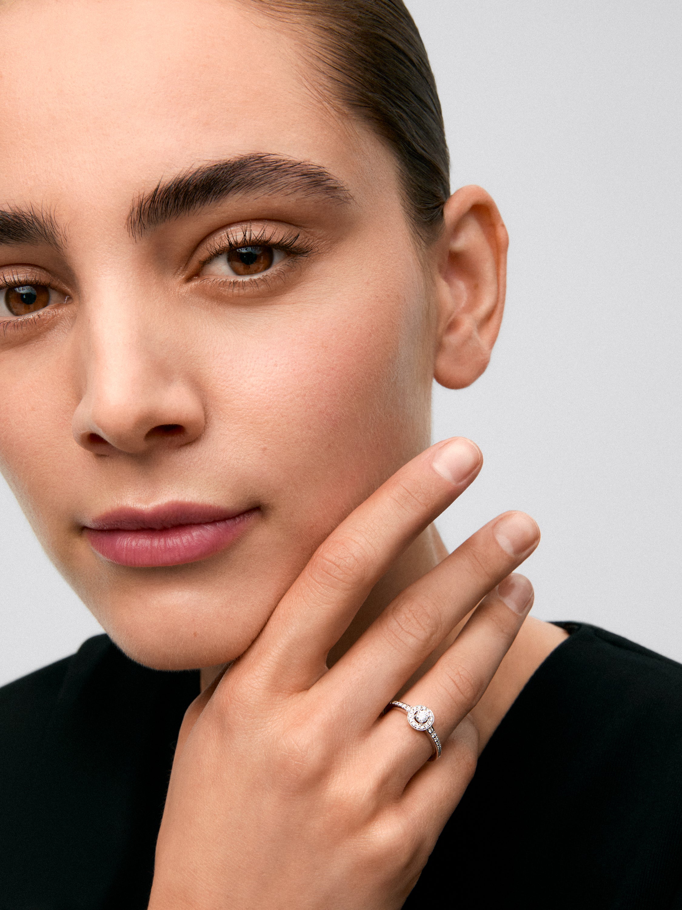 Anillo solitario de oro blanco de 18K con diamante central en talla brillante de 0,15 cts y orla y brazo con 30 diamantes en talla brillante con un total de 0,28 cts