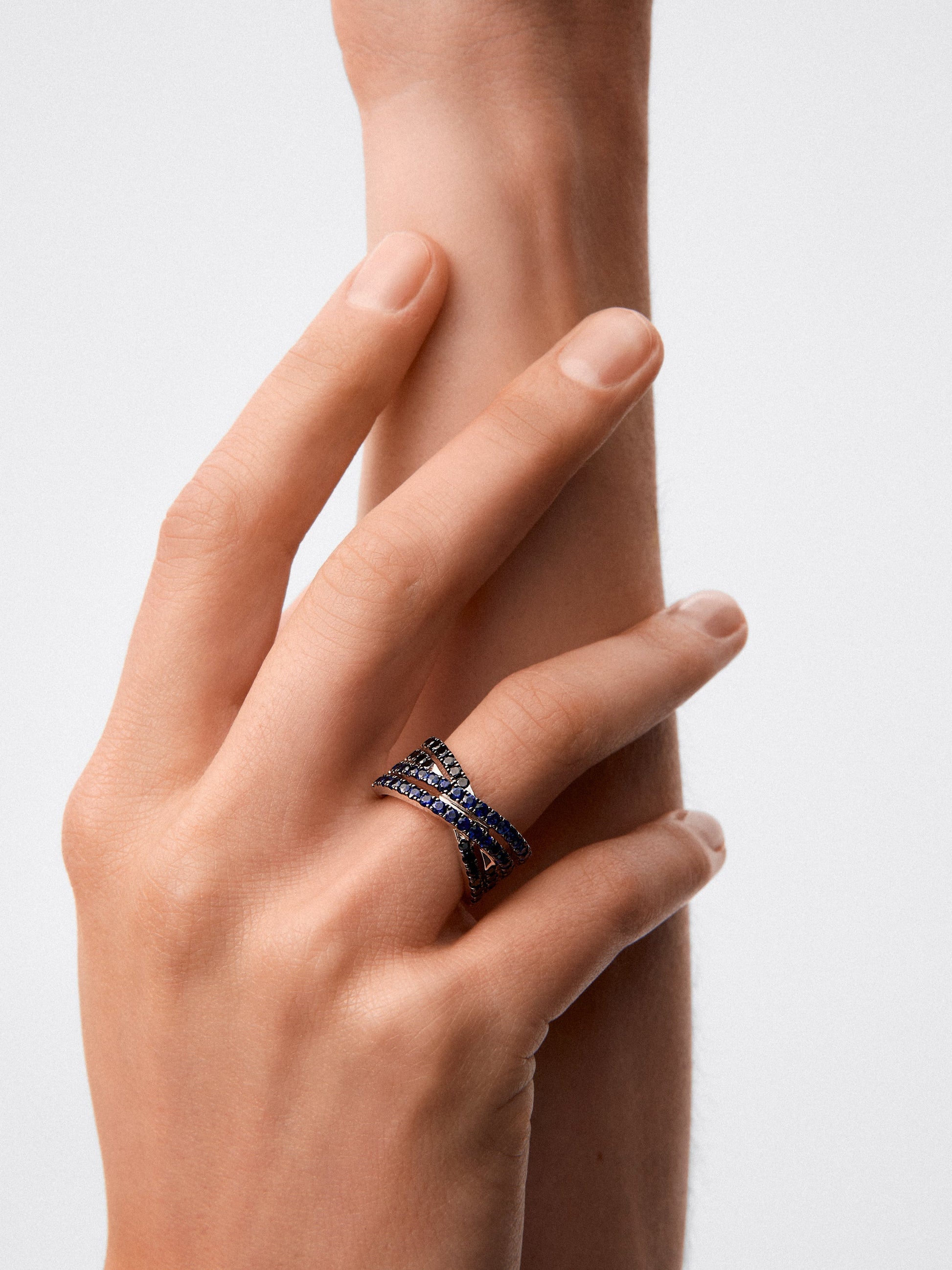 Anillo cruzado de doble brazo de plata 925 con 36 zafiros azules en talla brillante con un total de 1,26 cts y 22 espinelas negras con un total de 0,63 cts