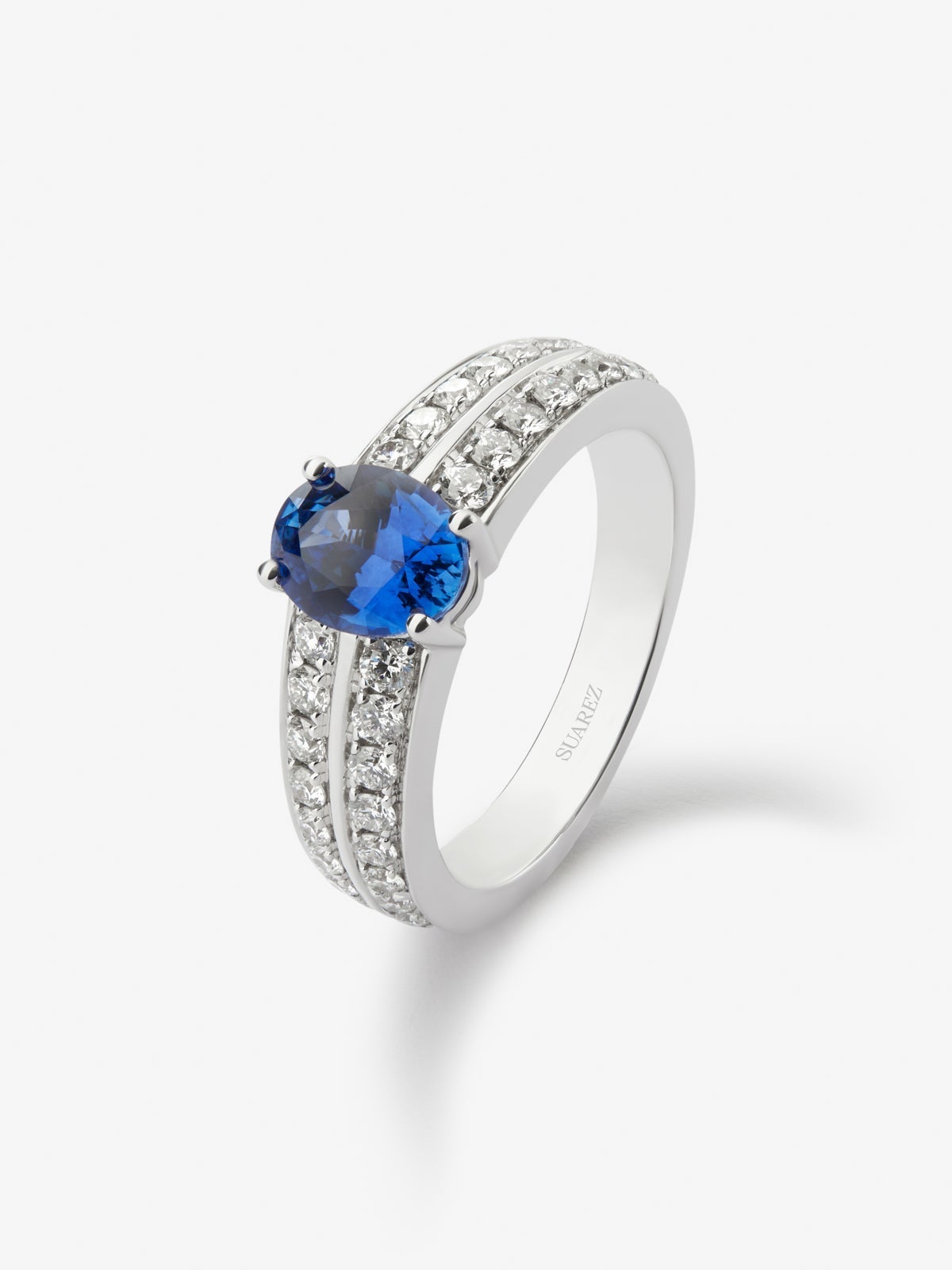 Anillo de oro blanco de 18K con zafiro azul vivid en talla oval de 1,225 cts y 32 diamantes en talla brillante con un total de 0,61 cts