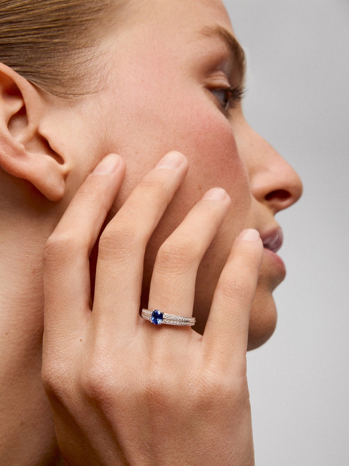 Anillo de oro blanco de 18K con zafiro azul vivid en talla oval de 1,292 cts y 32 diamantes en talla brillante con un total de 0,6 cts