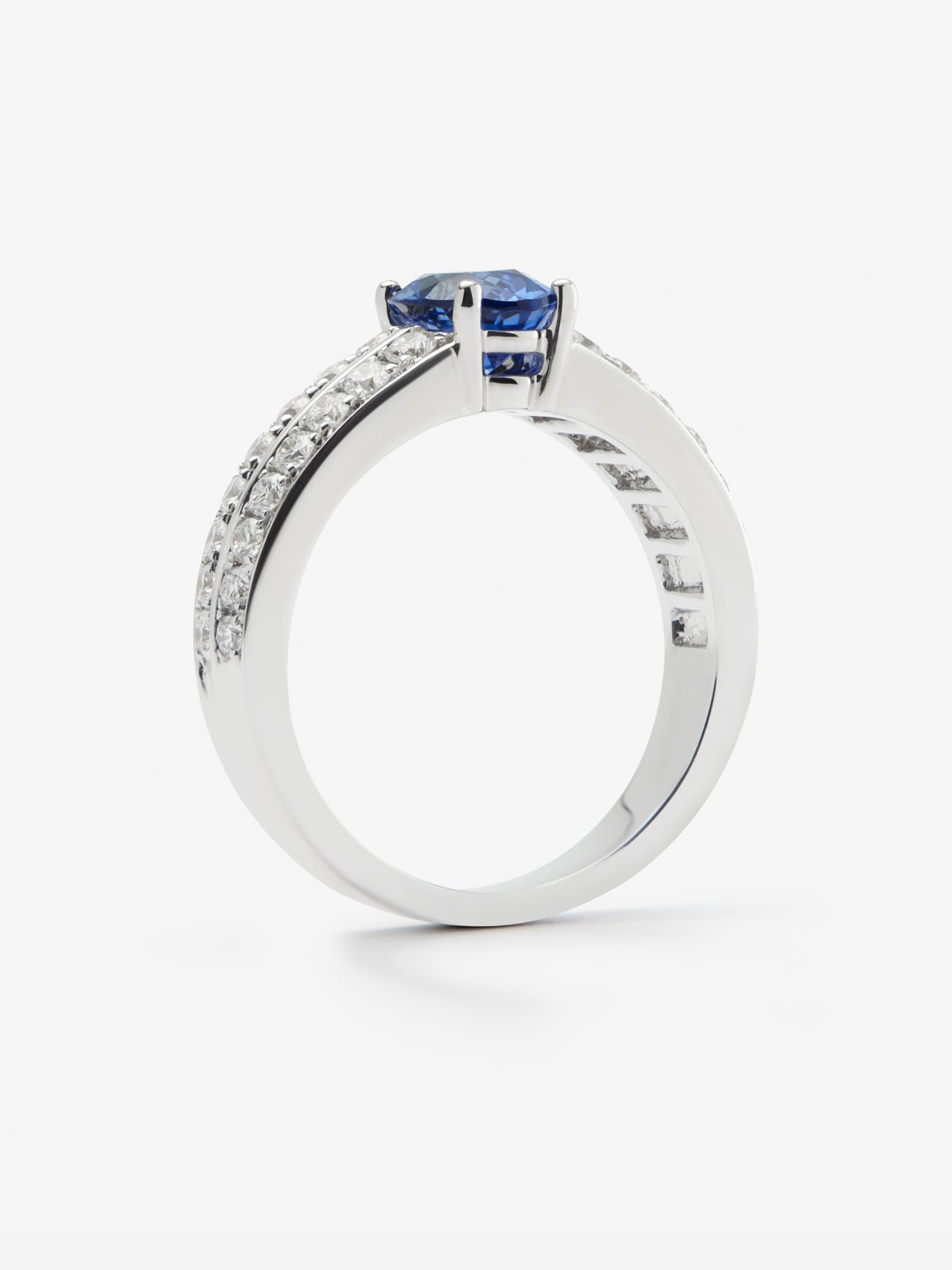 Anillo de oro blanco de 18K con zafiro azul vivid en talla oval de 1,292 cts y 32 diamantes en talla brillante con un total de 0,6 cts