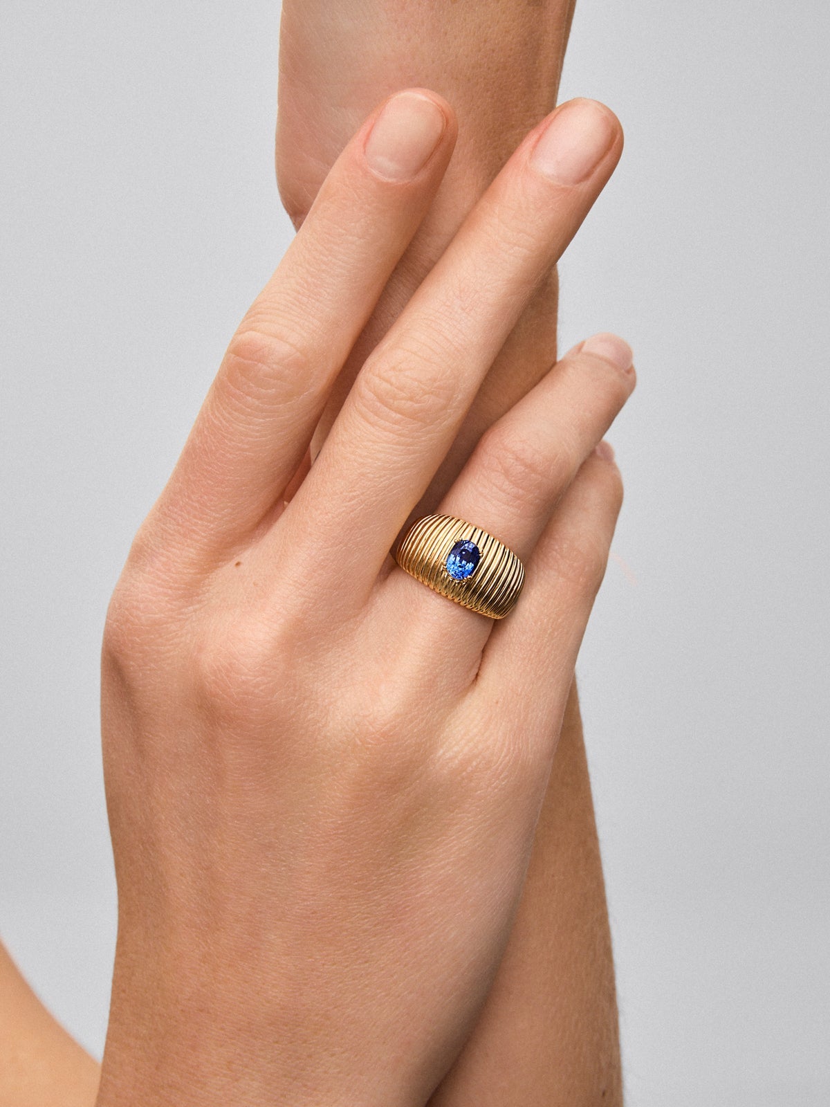 Anillo gallonado de oro amarillo de 18K con zafiro azul en talla oval
