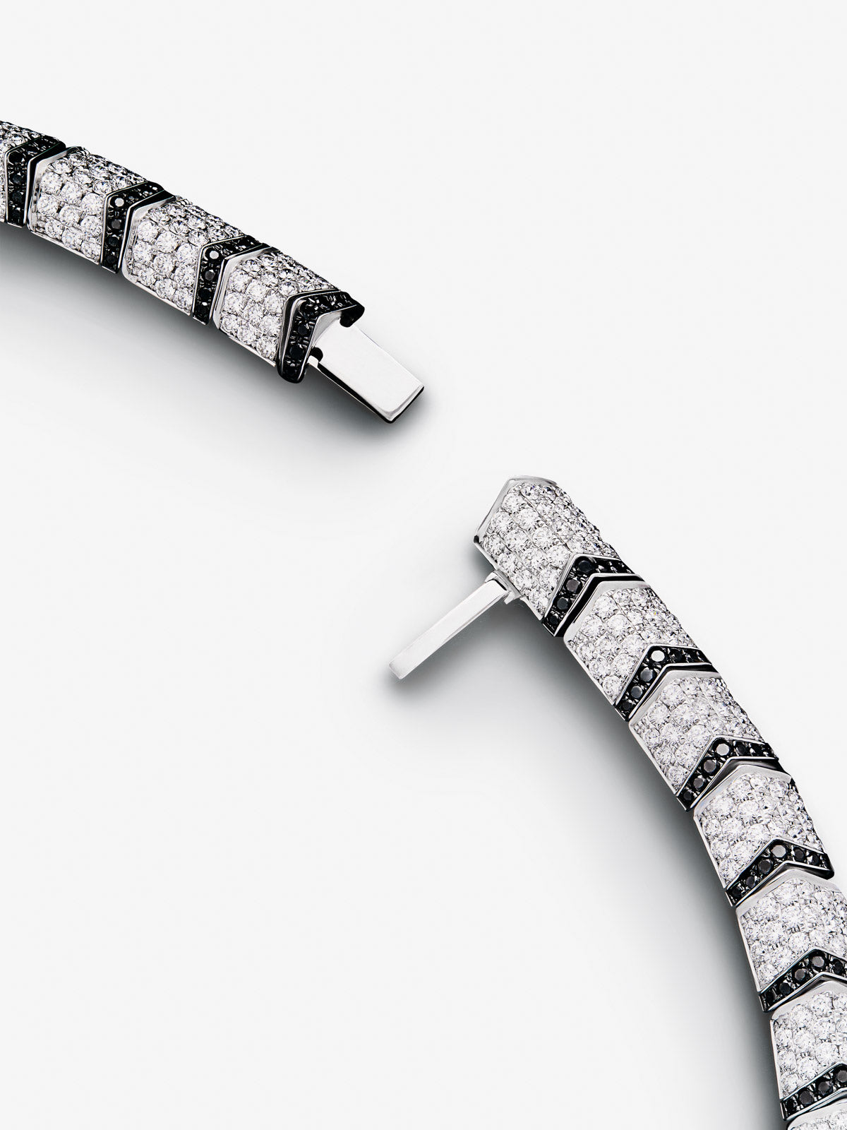 Collar rígido con forma de tigre de oro blanco de 18K con diamantes blancos y negros en talla brillante con un total de 22,7 cts y 2 esmeraldas en talla trapecio con un total de 0,13 cts