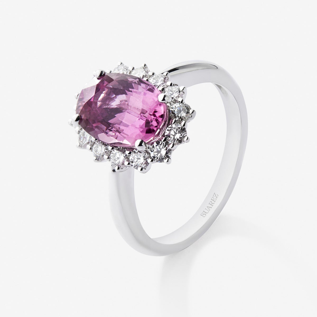 Anillo de oro blanco de 18K con zafiro rosa en talla oval de 0,55 cts y 12 diamantes en talla brillante con un total de 0,1 cts