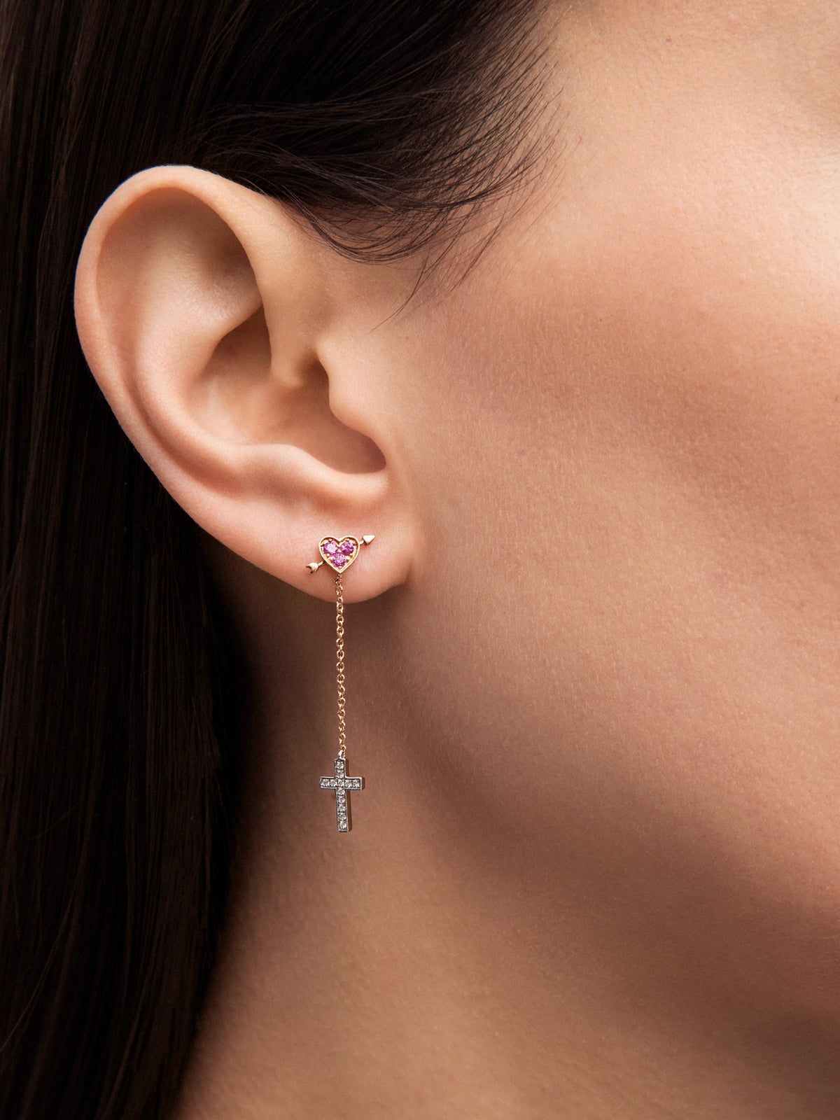 Pendiente individual de oro blanco y rosa de 18K con 3 zafiros rosas en talla brillante con un total de 0,09 cts y 12 diamantes en talla brillante con un total de 0,04 cts y forma de corazón y cruz