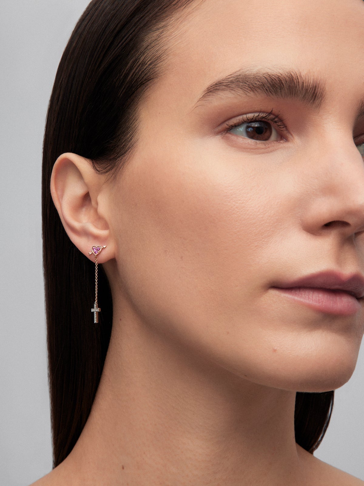Pendiente individual de oro blanco y rosa de 18K con 3 zafiros rosas en talla brillante con un total de 0,09 cts y 12 diamantes en talla brillante con un total de 0,04 cts y forma de corazón y cruz
