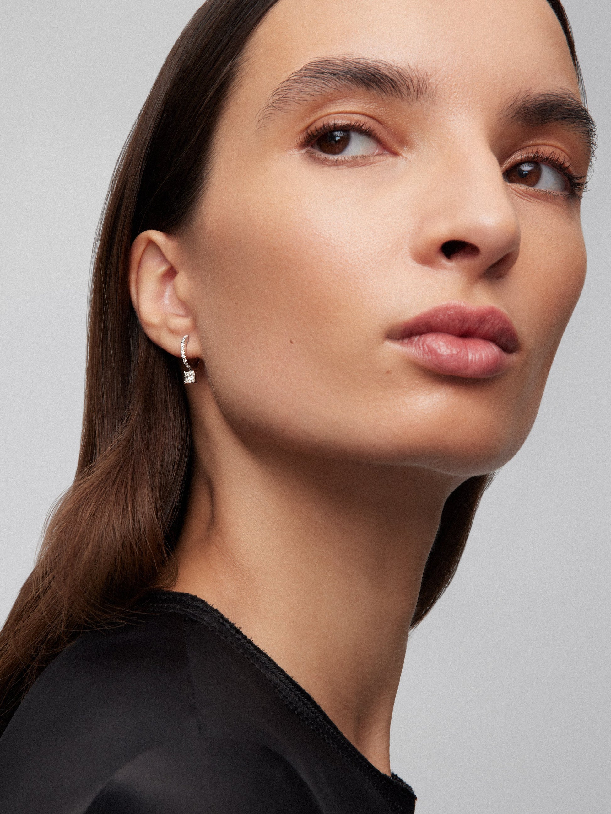 Pendientes de aro de oro blanco de 18K con dos diamantes en talla princesa con un total de 0,6 cts y 20 diamantes en talla brillante con un total de 0,19 cts