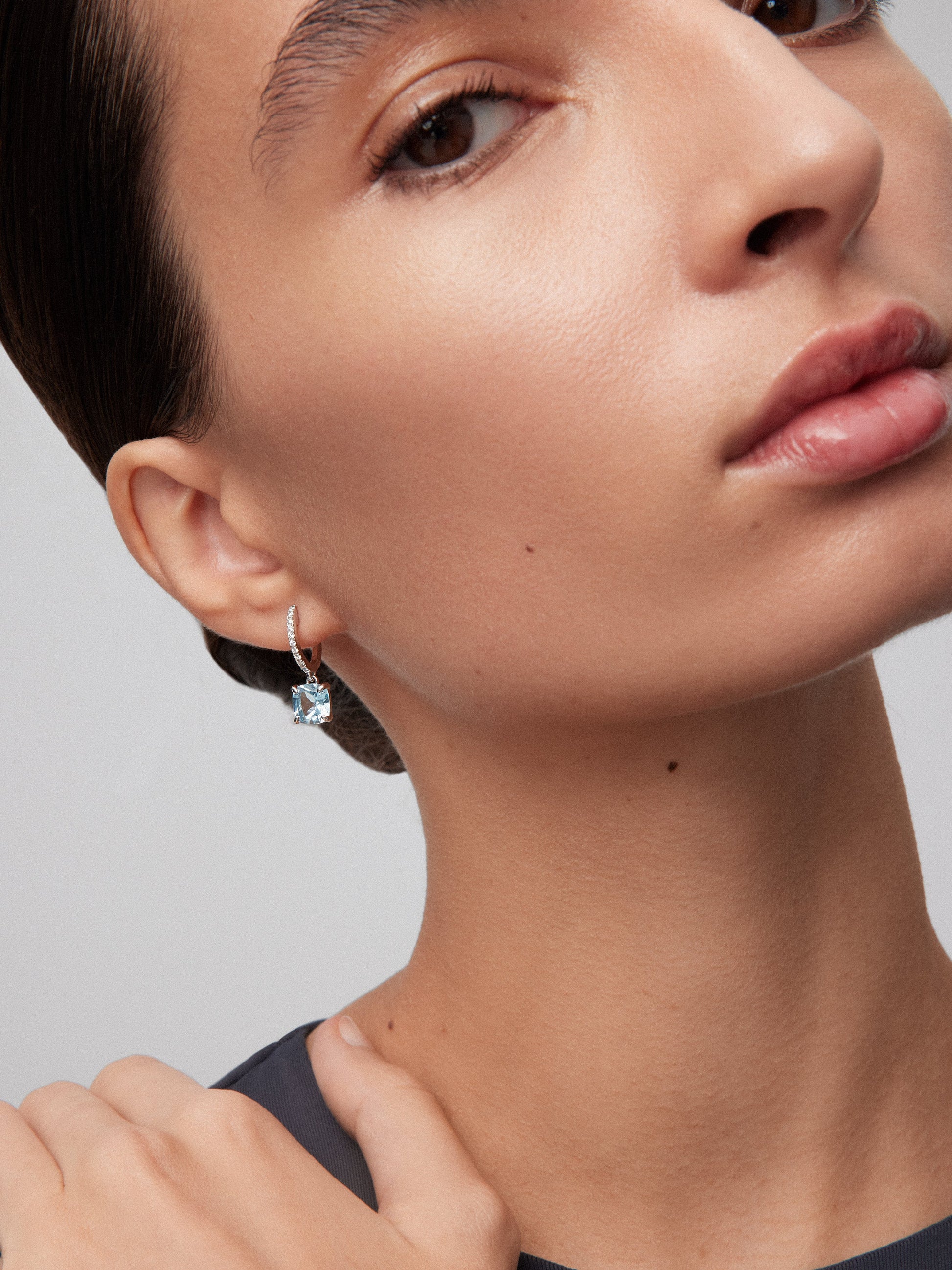 Pendientes de aro de oro blanco de 18K con 2 topacios azul sky en talla cushion con un total de 4,05 cts y 18 diamantes en talla brillante con un total de 0,14 cts