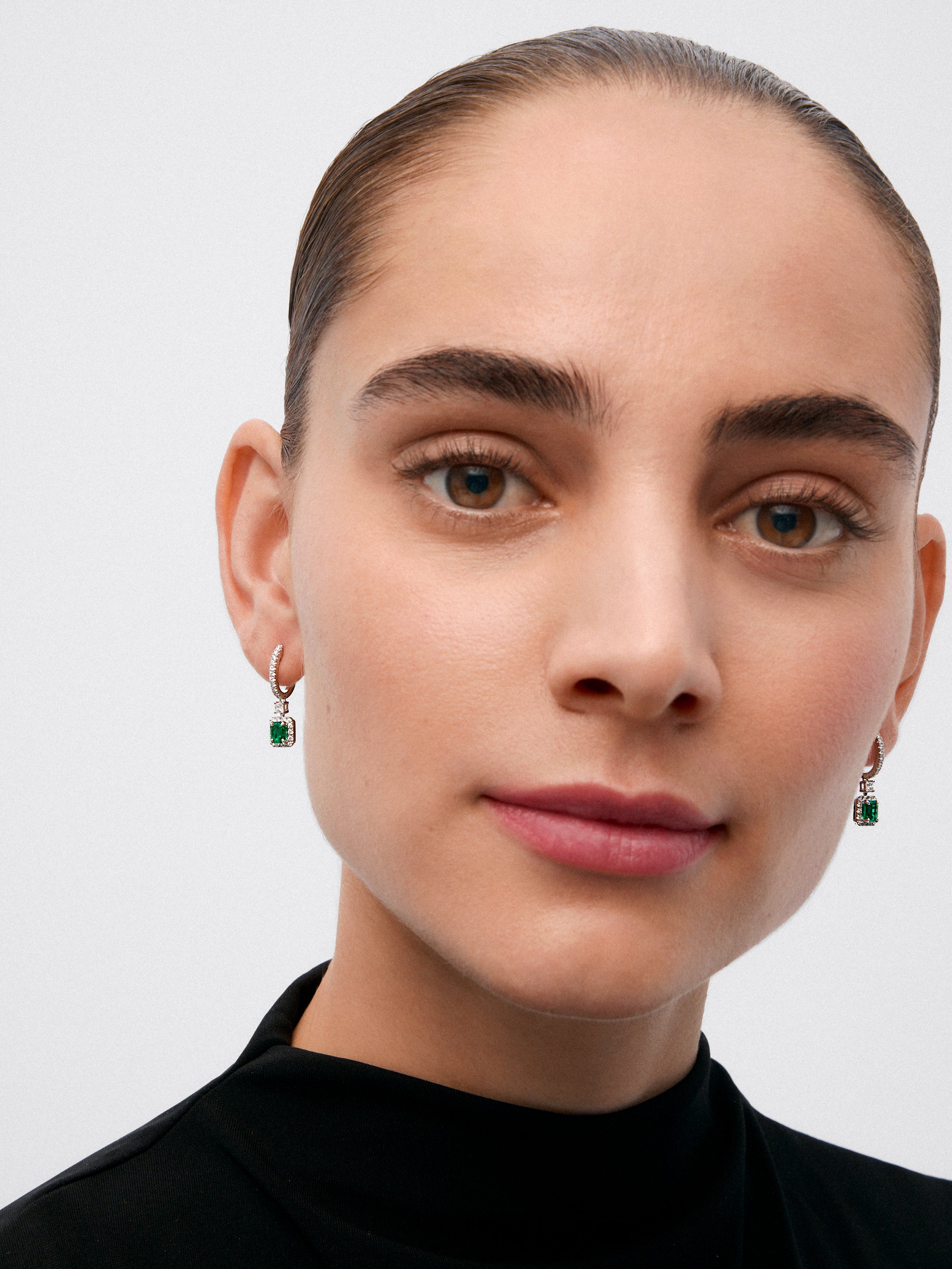 Pendientes de oro blanco de 18K con esmeraldas y diamantes.
