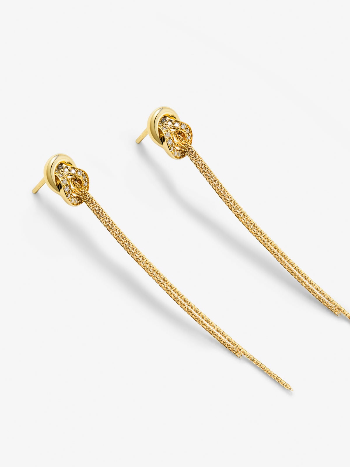 Pendientes largos de oro amarillo de 18K con diamantes blancos en talla brillante de 0,5 cts y forma de nudo