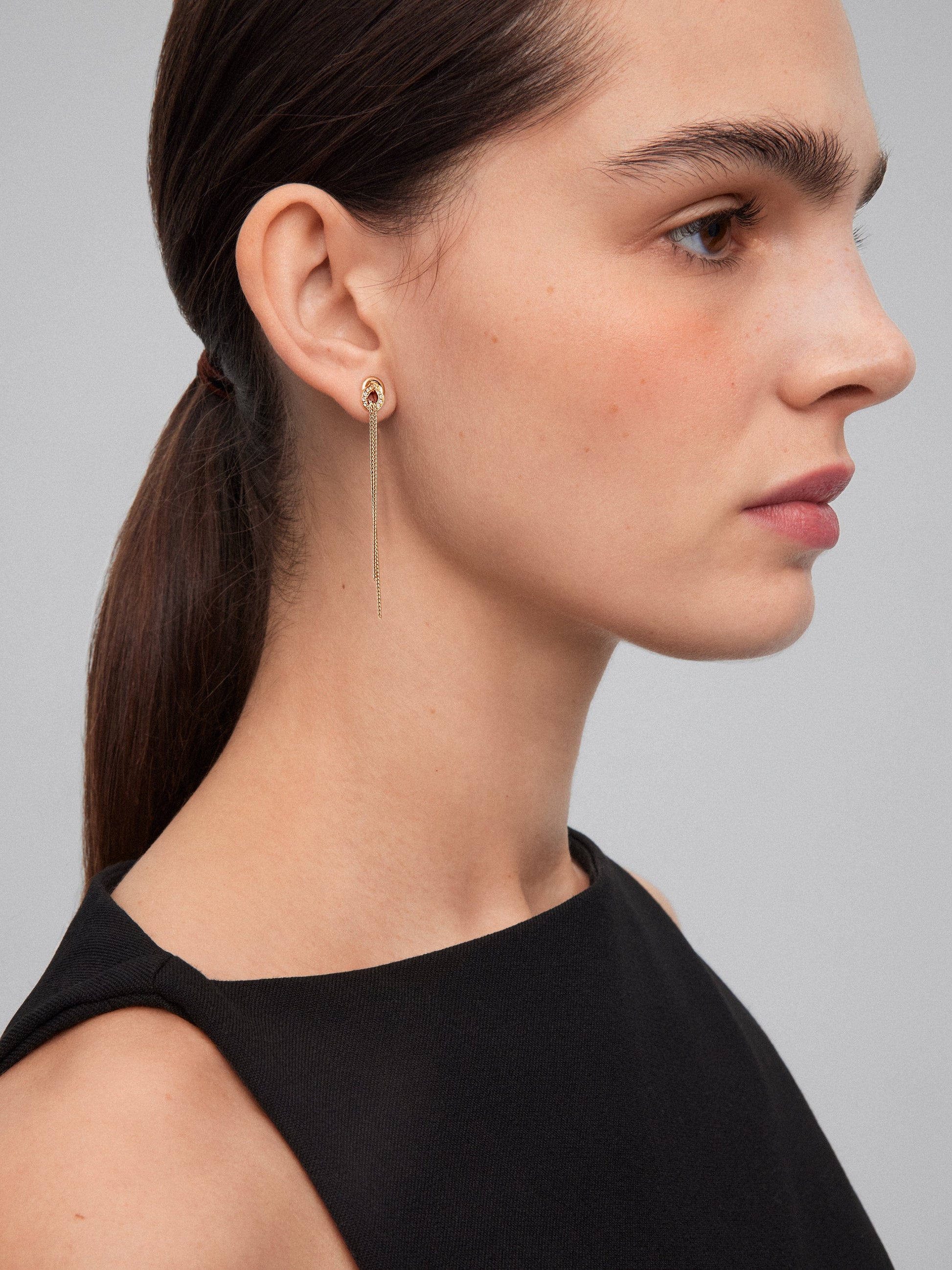 Pendientes largos de oro amarillo de 18K con diamantes blancos en talla brillante de 0,5 cts y forma de nudo