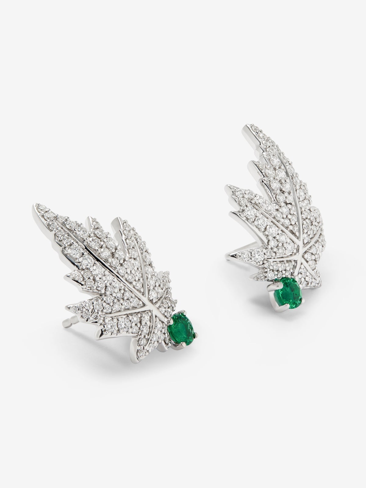 Pendientes de oro blanco de 18K con 2 esmeraldas centrales con un total de 0,28 cts, pavé de diamantes y forma de hoja de arce