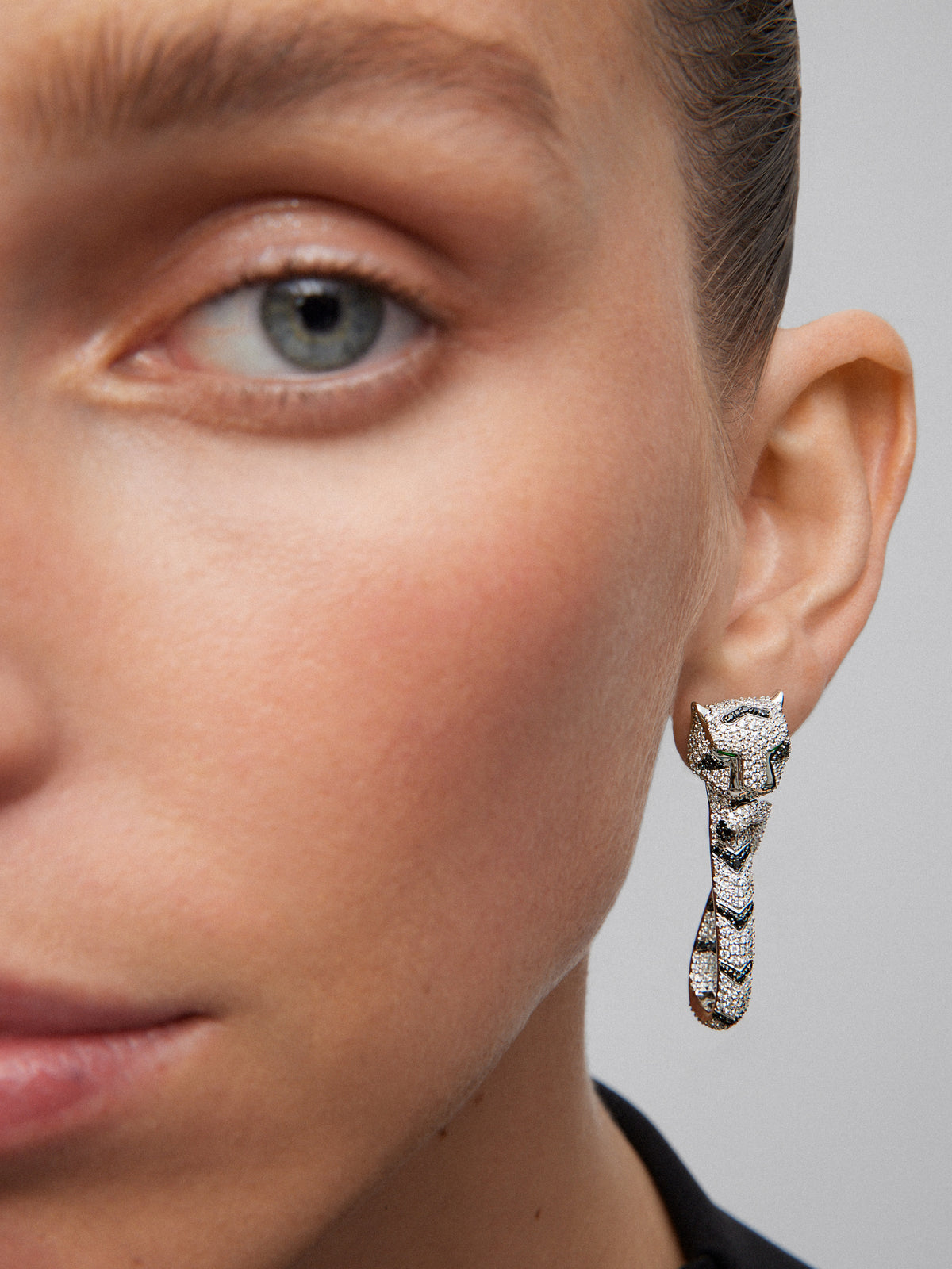 18K white gold earrings with 548 brilliant-cut white diamonds with a total of 2.68 cts, 90 black diamonds with a total of 0.47 cts, and 2 trapezoid-cut emeralds with a total of 0.26 cts shaped tiger