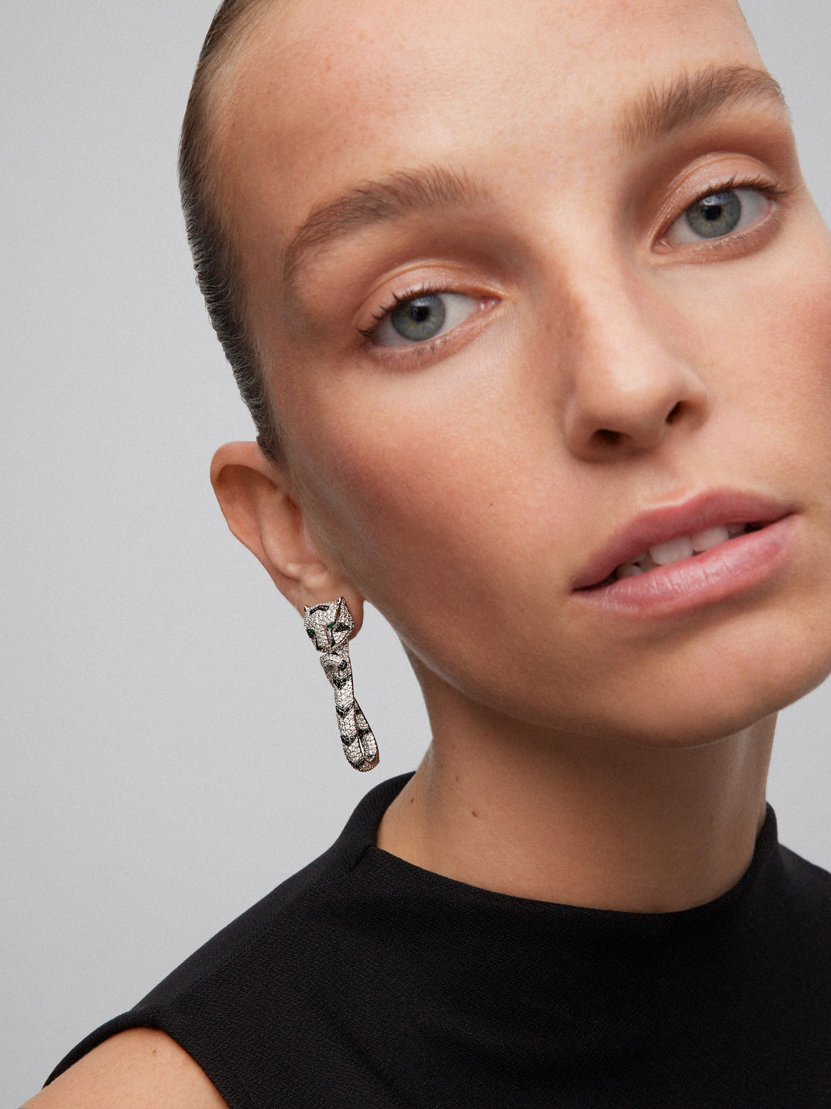 18K white gold earrings with 548 brilliant-cut white diamonds with a total of 2.68 cts, 90 black diamonds with a total of 0.47 cts, and 2 trapezoid-cut emeralds with a total of 0.26 cts shaped tiger