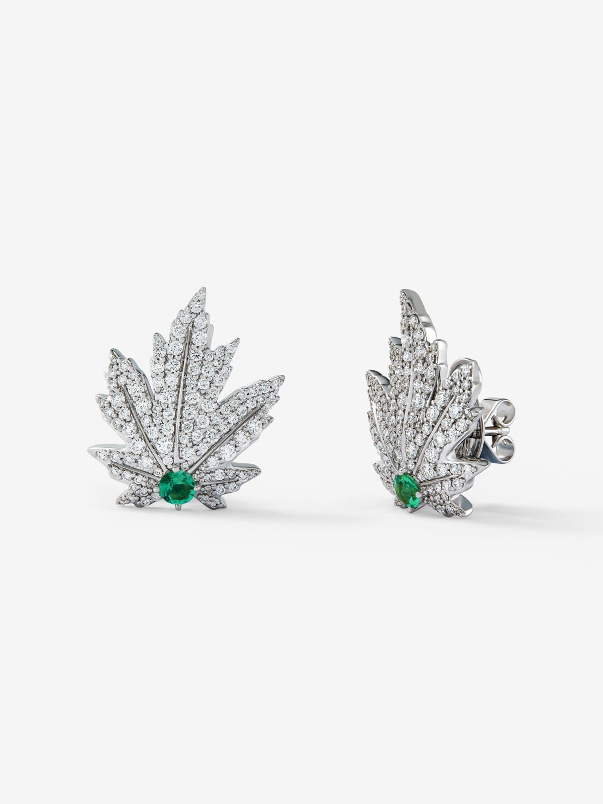 Pendientes de oro blanco de 18K con 2 esmeraldas centrales con un total de 0,34 cts, pavé de diamantes y forma de hoja de arce