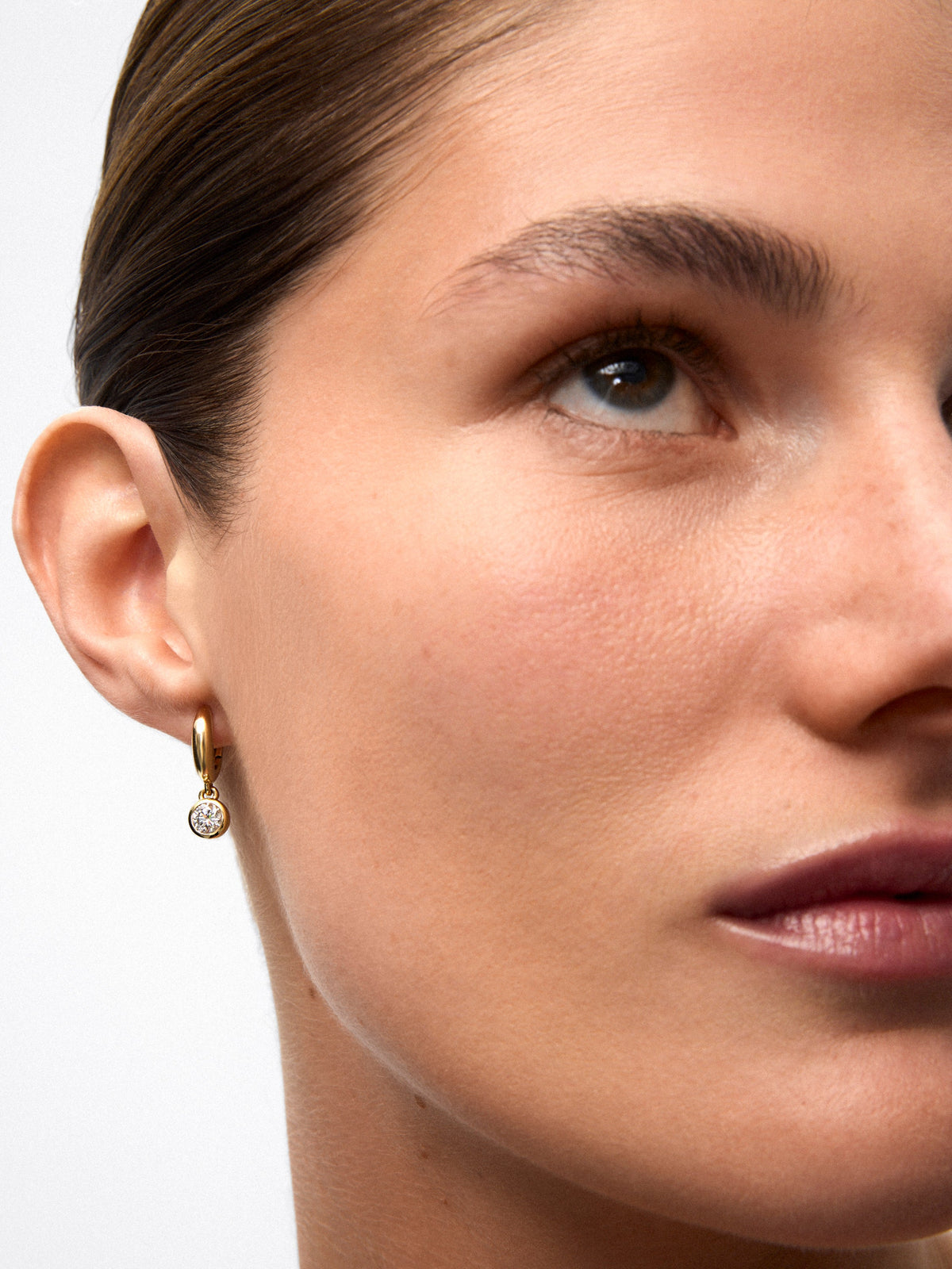 Pendientes de aro en oro amarillo de 18K con 2 diamantes en talla brillante con un total de 0,8 cts