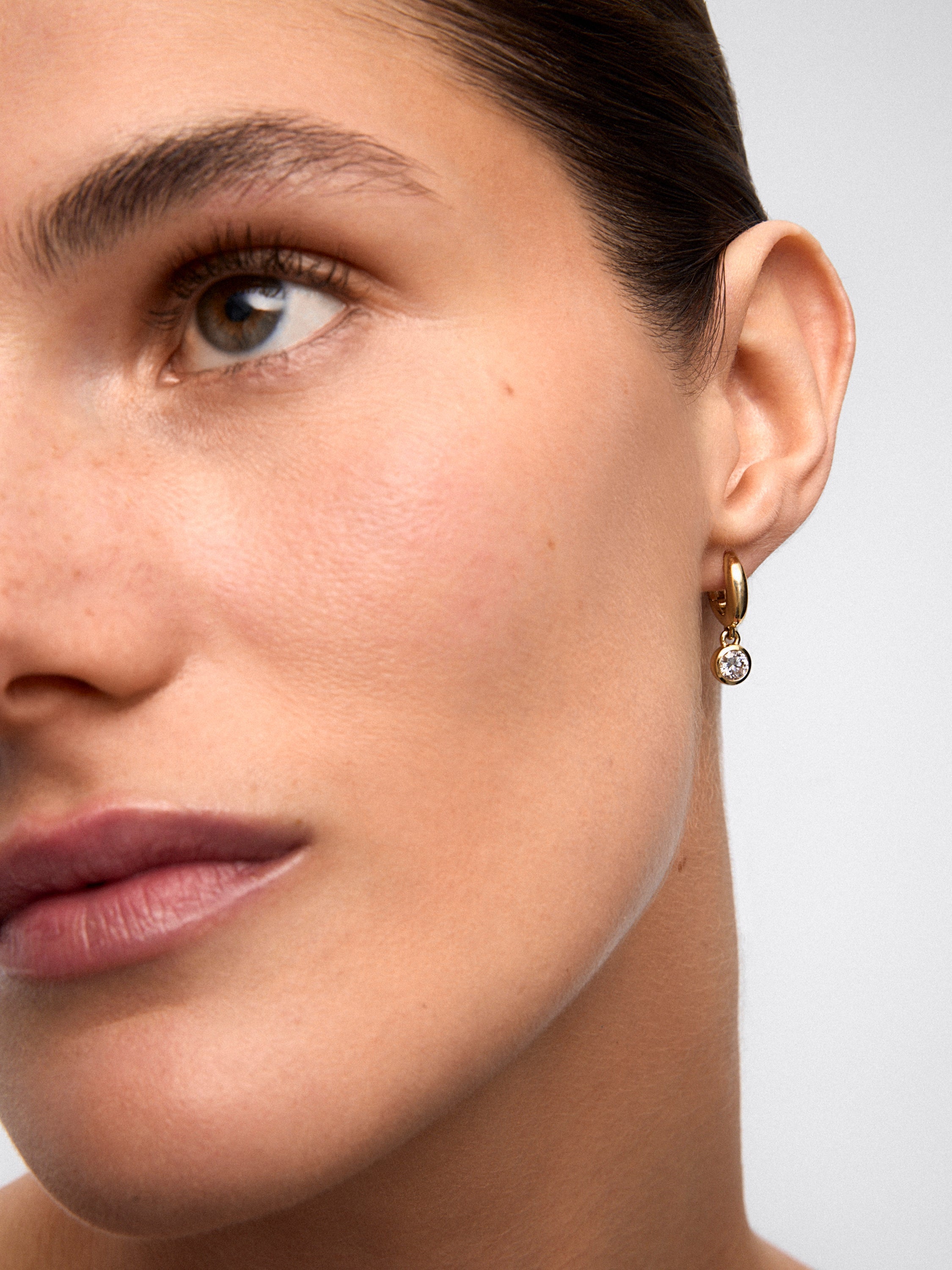 Pendientes de aro en oro amarillo de 18K con 2 diamantes en talla brillante con un total de 0,8 cts