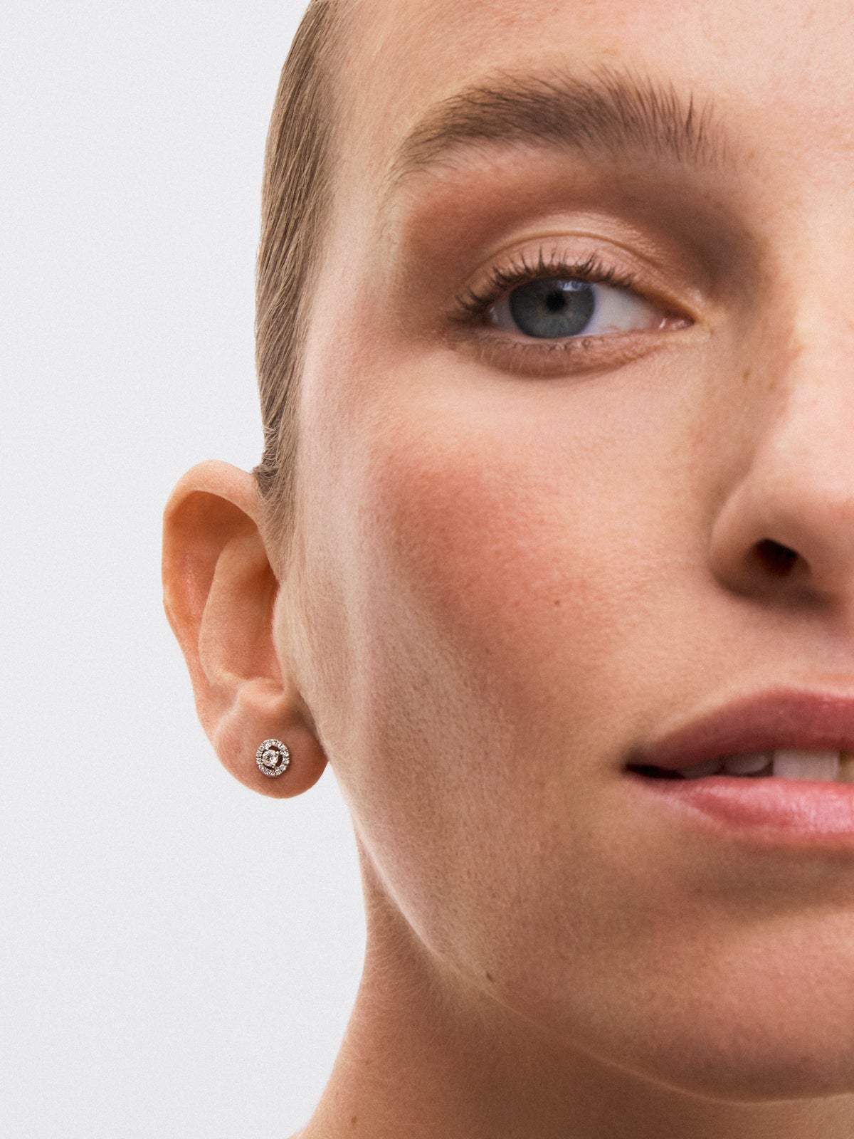 Pendientes de oro blanco de 18K con diamante solitario y orla de diamantes