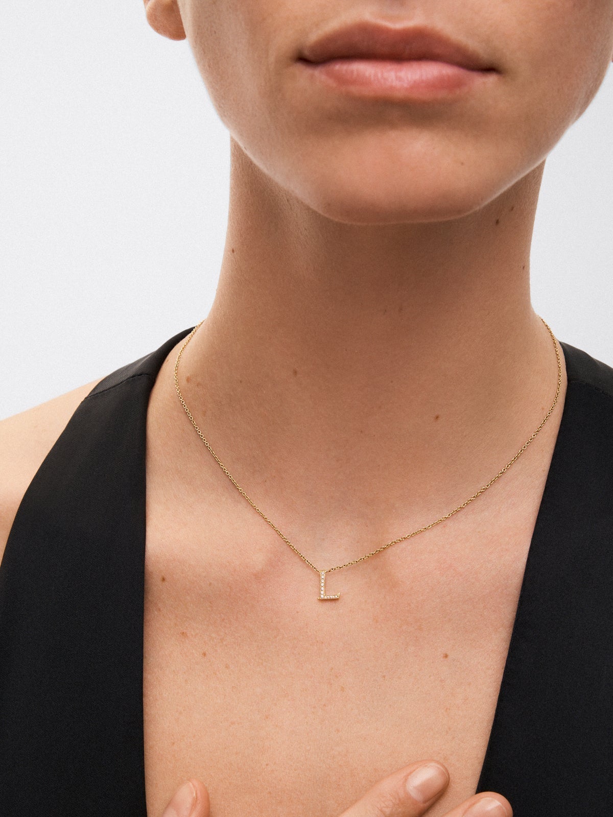 Colgante de oro amarillo de 18K con letra L y 12 diamantes en talla brillante con un total de 0,07 cts