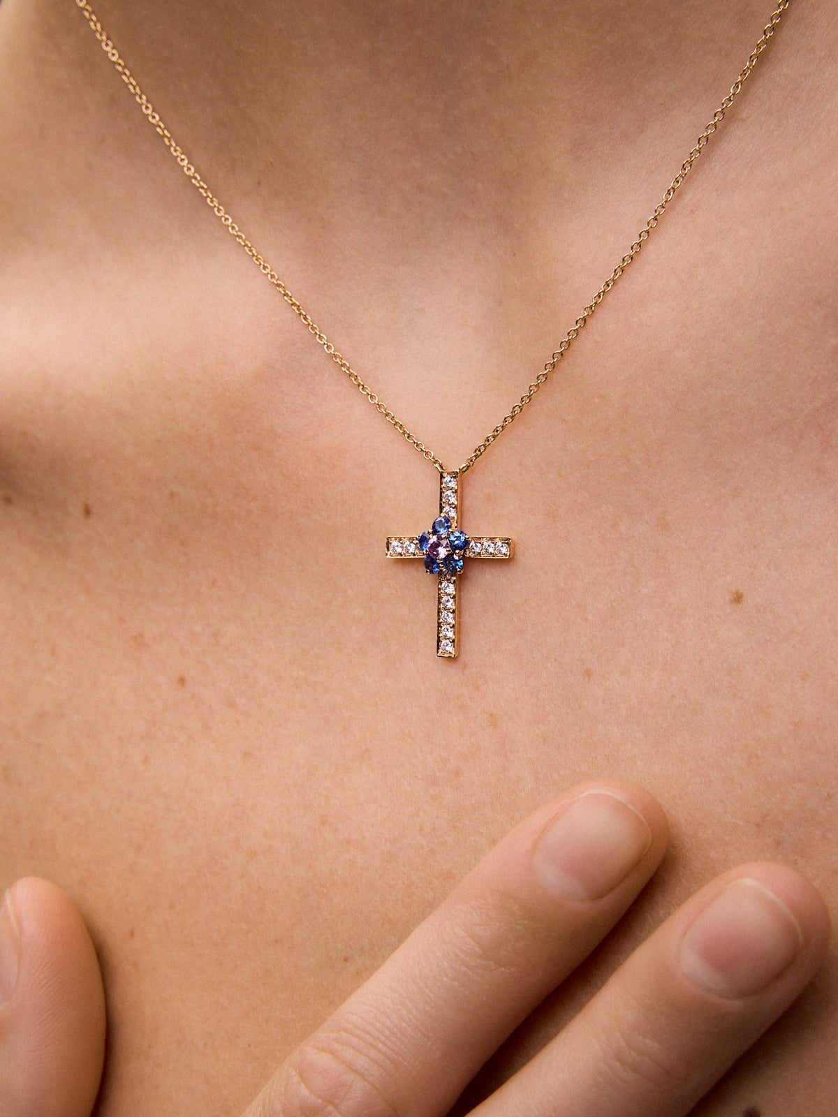 Colgante cadena cruz de oro rosa de 18K con 15 diamantes en talla brillante con un total de 0,27 cts, 5 zafiros azules en talla brillante con un total de 0,36 cts y zafiro rosa en talla brillante de 0,11 cts