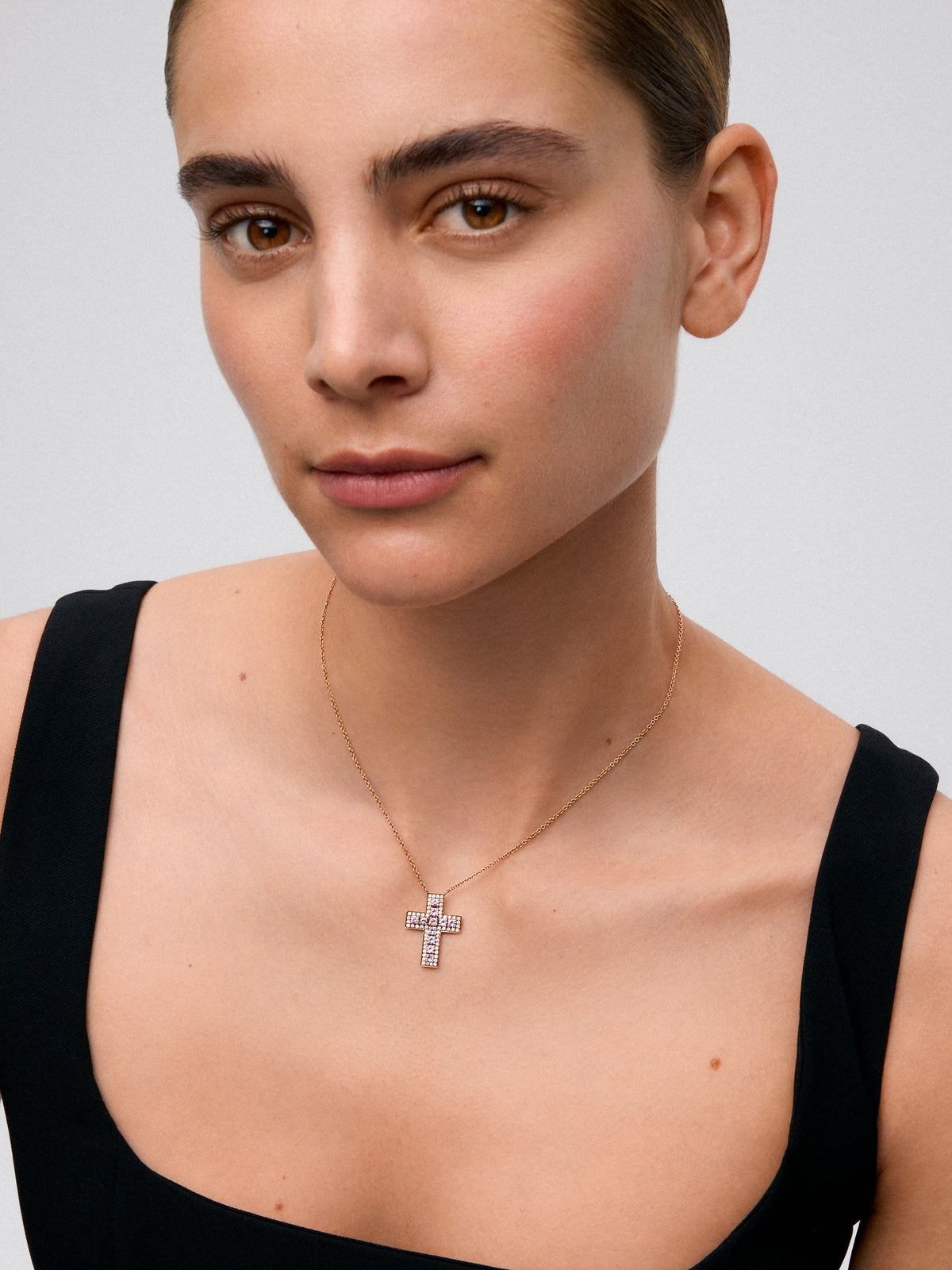 Colgante de cruz de oro rosa de 18K con diamantes en talla brillante de 0,37 cts y zafiros rosas en talla brillante de 1,06 cts