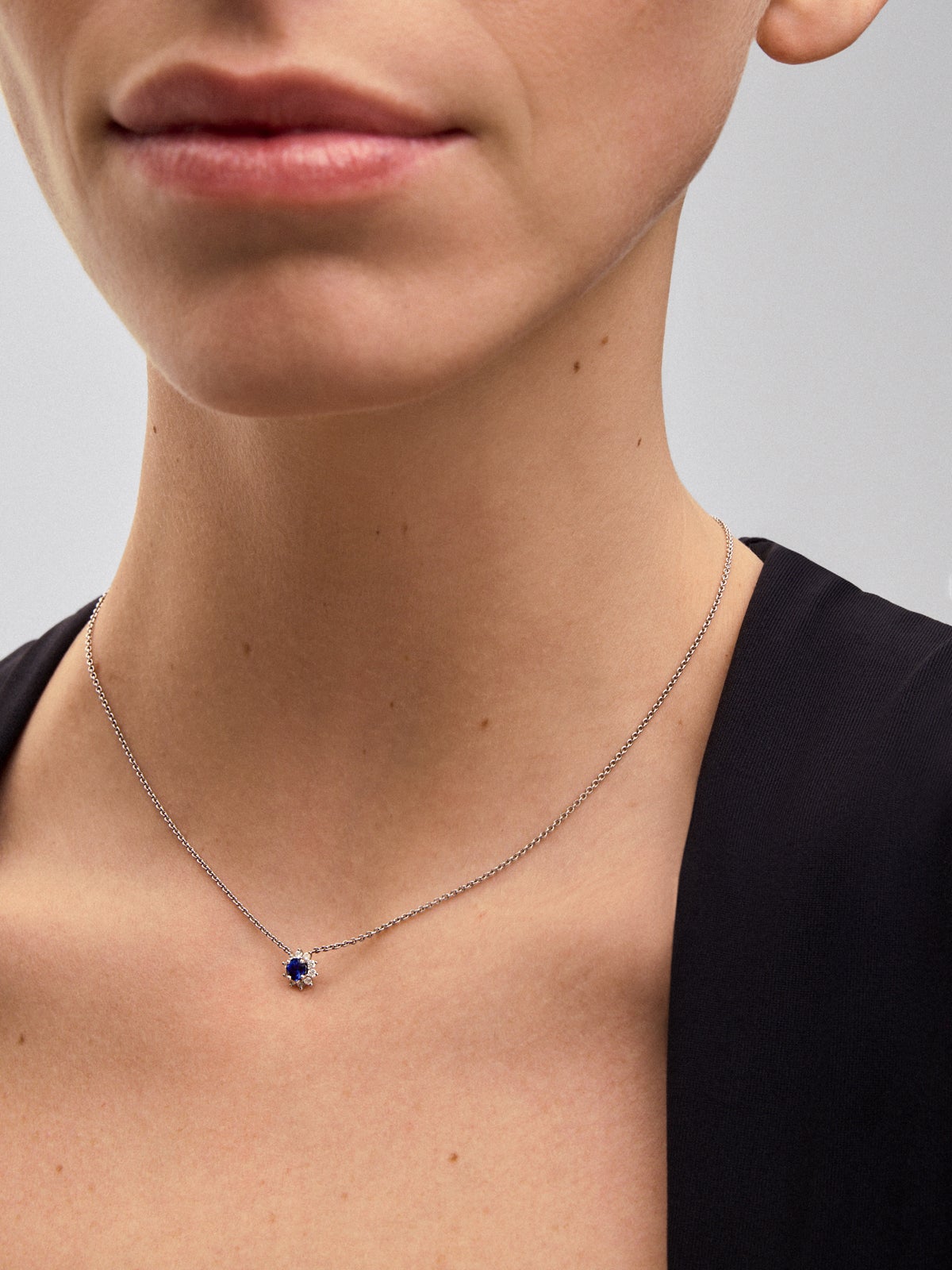 Colgante de oro blanco de 18K con un zafiro azul en talla brillante de 0,37 cts y 10 diamantes en talla brillante con un total de 0,14 cts con forma de estrella