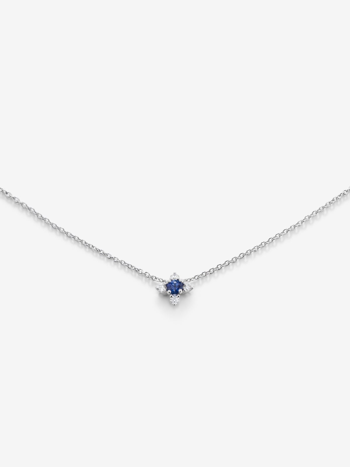 Colgante de oro blanco de 18K con un zafiro azul en talla brillante de 0,12 cts y 4 diamantes en talla brillante con un total de 0,08 cts