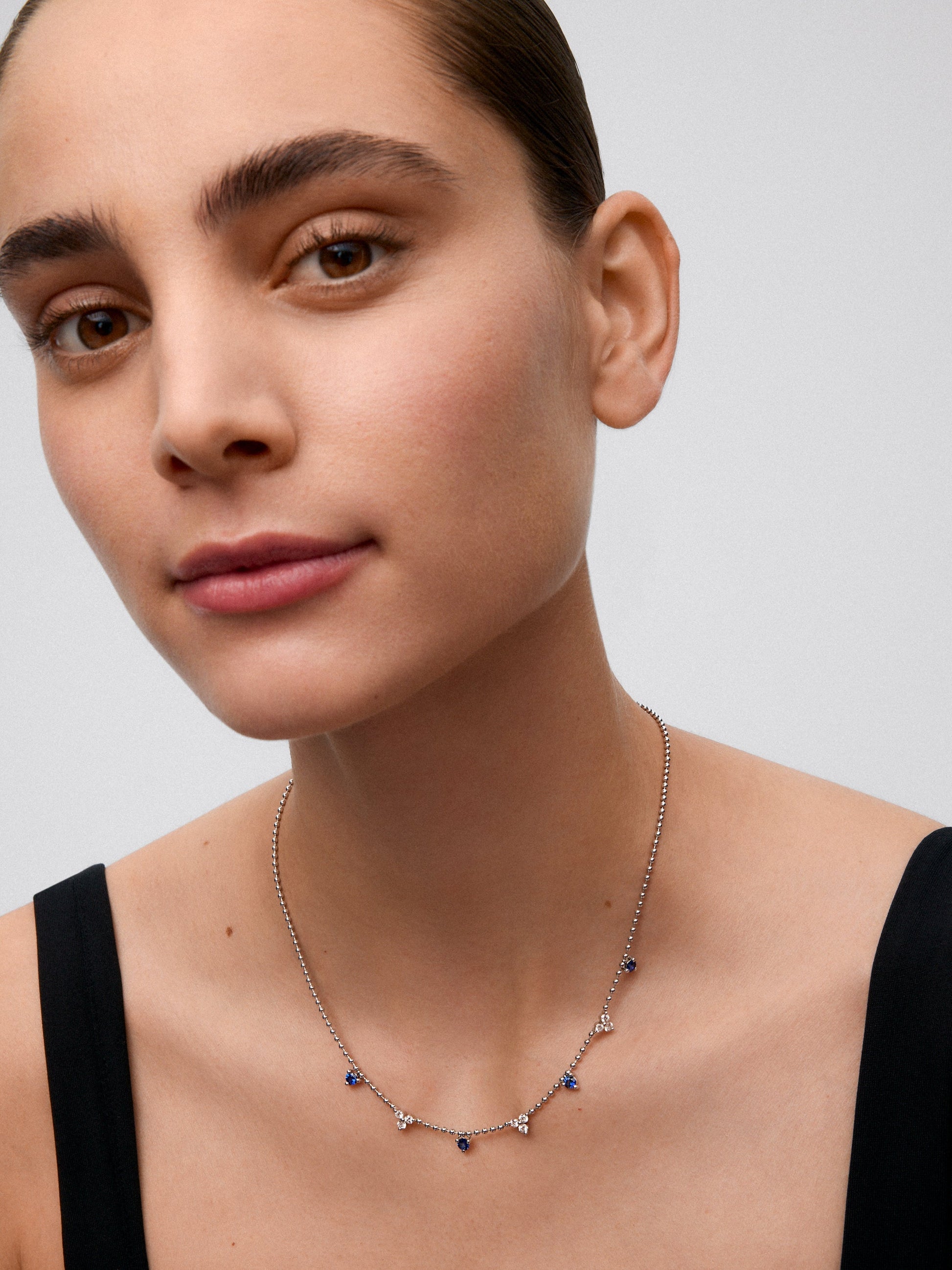 Colgante de oro blanco de 18K con 4 zafiros azules en talla brillante con un total de 0,85 cts y 9 diamantes en talla brillante con un total de 0,54 cts