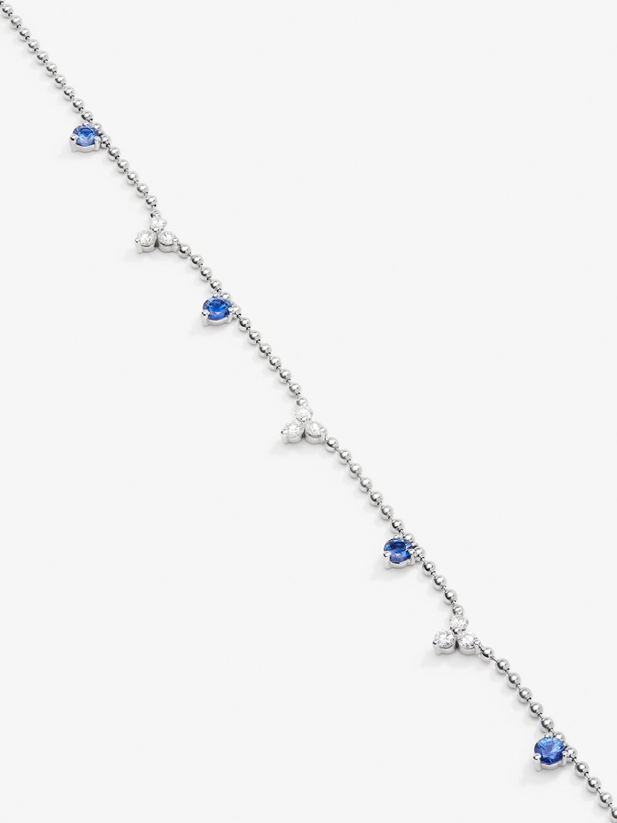 Colgante de oro blanco de 18K con 4 zafiros azules en talla brillante con un total de 0,85 cts y 9 diamantes en talla brillante con un total de 0,54 cts
