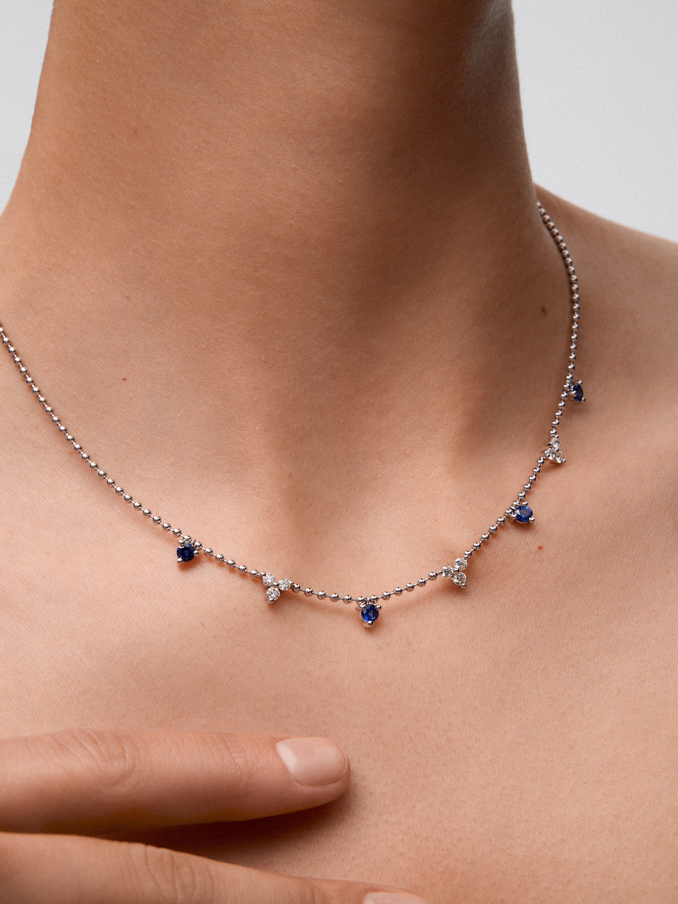 Colgante de oro blanco de 18K con 4 zafiros azules en talla brillante con un total de 0,85 cts y 9 diamantes en talla brillante con un total de 0,54 cts