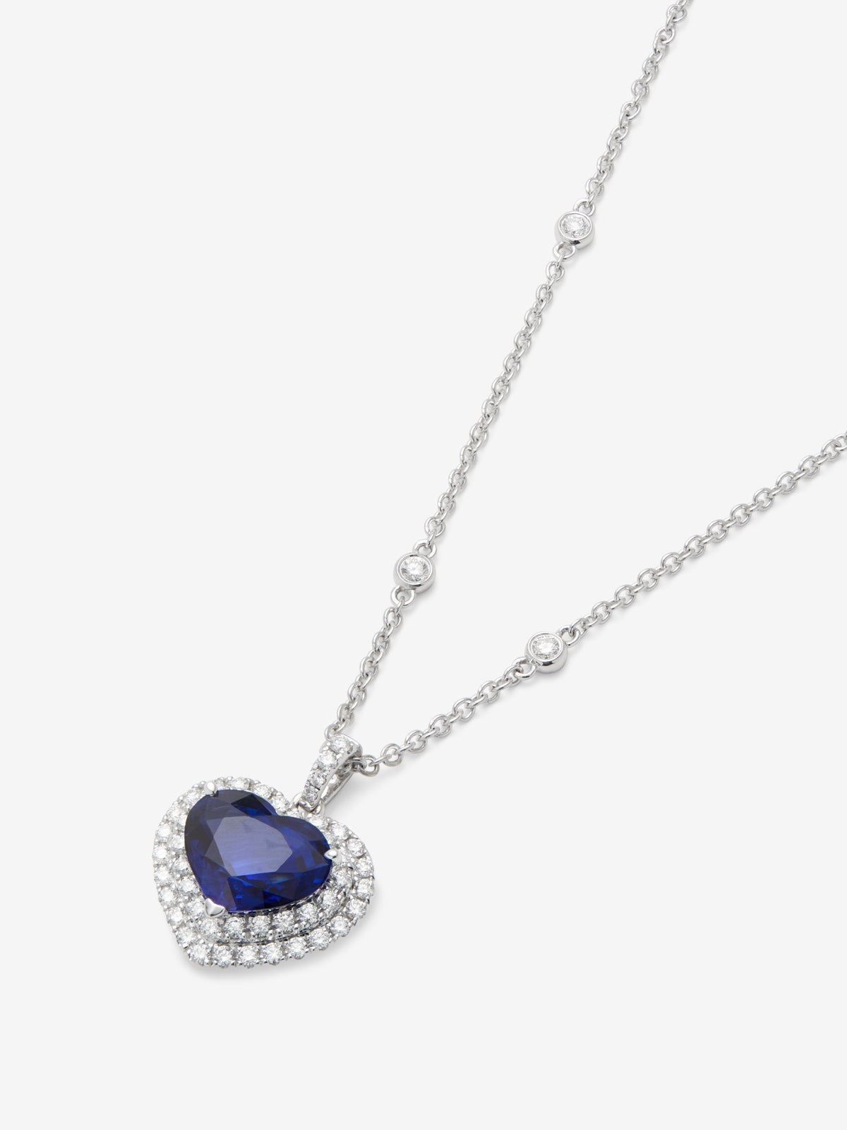 Colgante de oro blanco de 18K con zafiro azul royal en talla corazón de 1,51 cts y 59 diamantes en talla brillante con un total de 0,3 cts