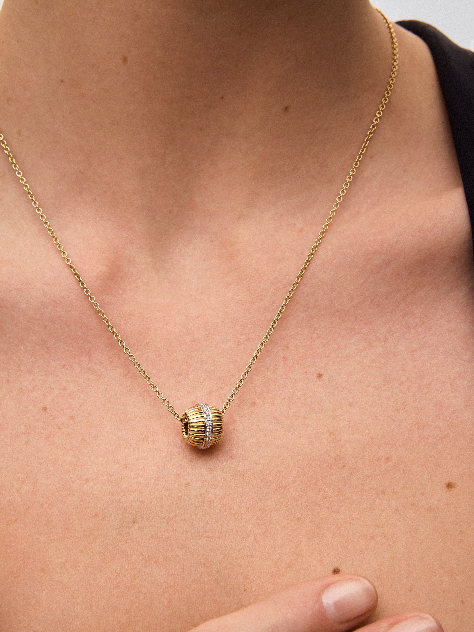 Colgante gallonado de oro blanco y amarillo de 18K con pavé de diamantes en talla brillante con un total de 0,19 cts