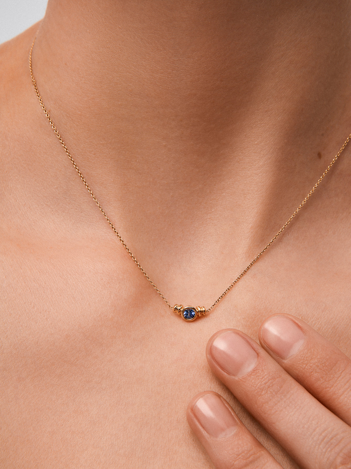 Colgante de oro amarillo de 18K con zafiro azul en talla brillante de 0,15 cts