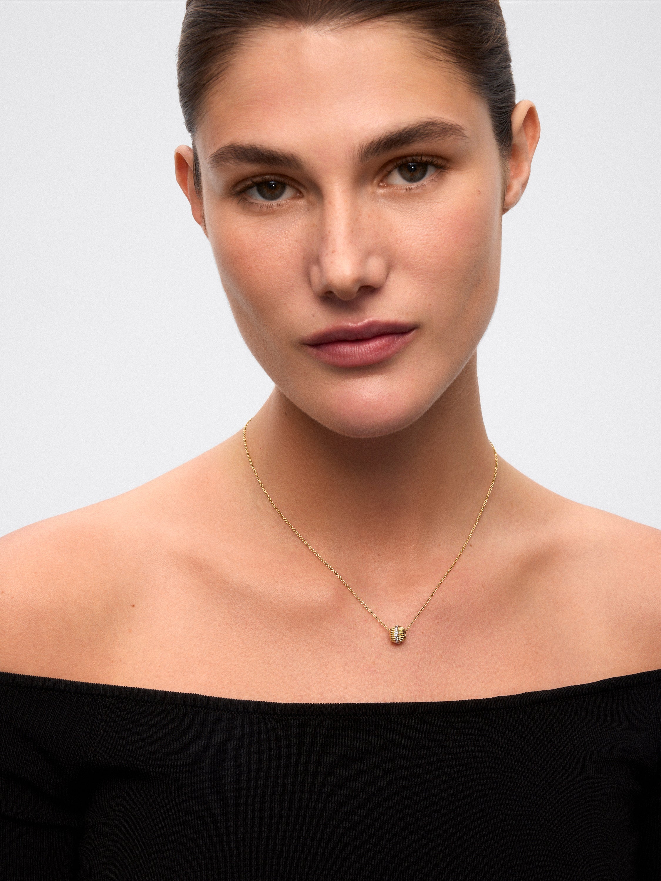 Colgante gallonado de oro blanco y amarillo de 18K con pavé de diamantes en talla brillante con un total de 0,115 cts