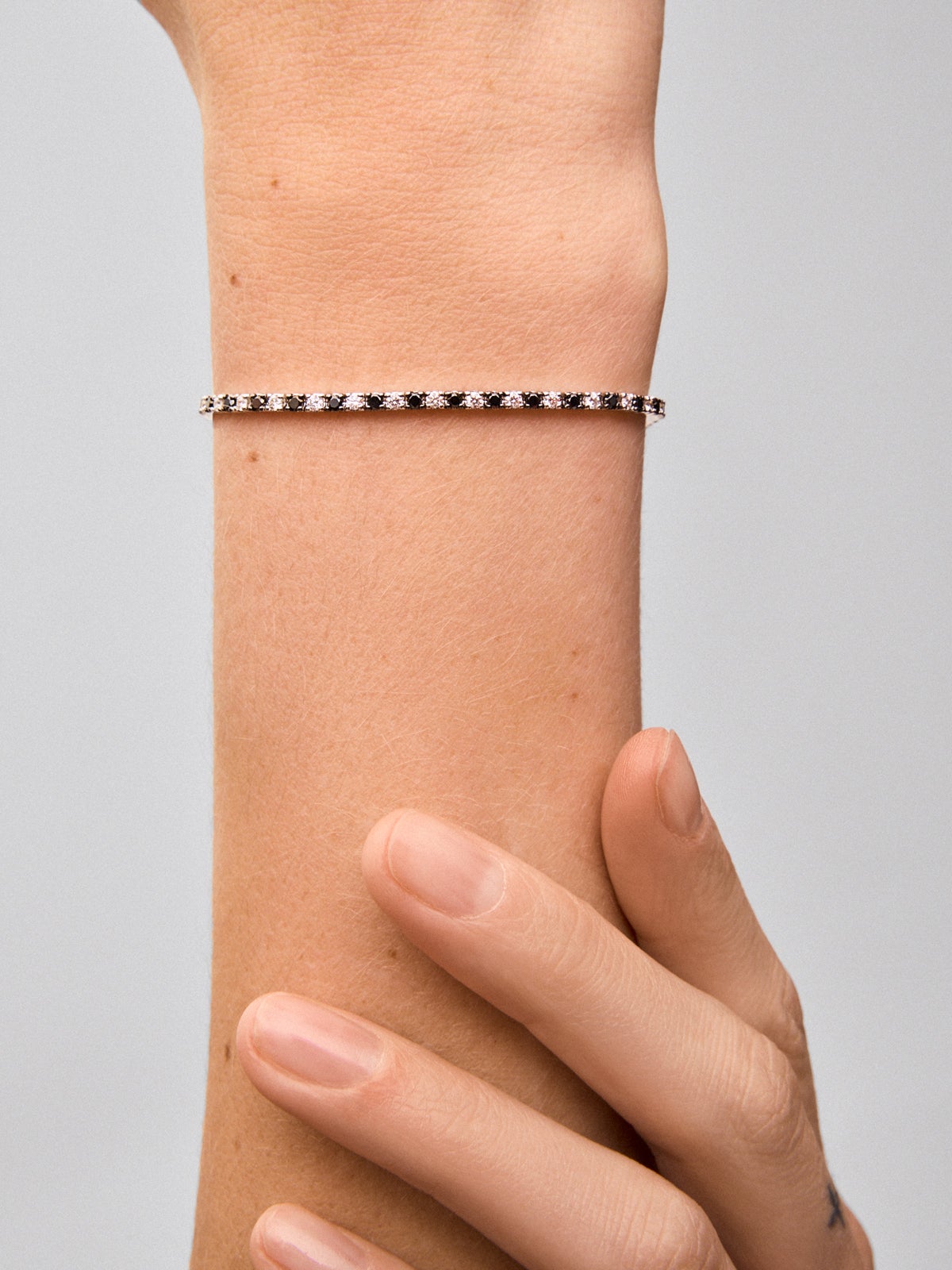 Pulsera riviere de oro blanco de 18K con diamante negro y diamante blanco