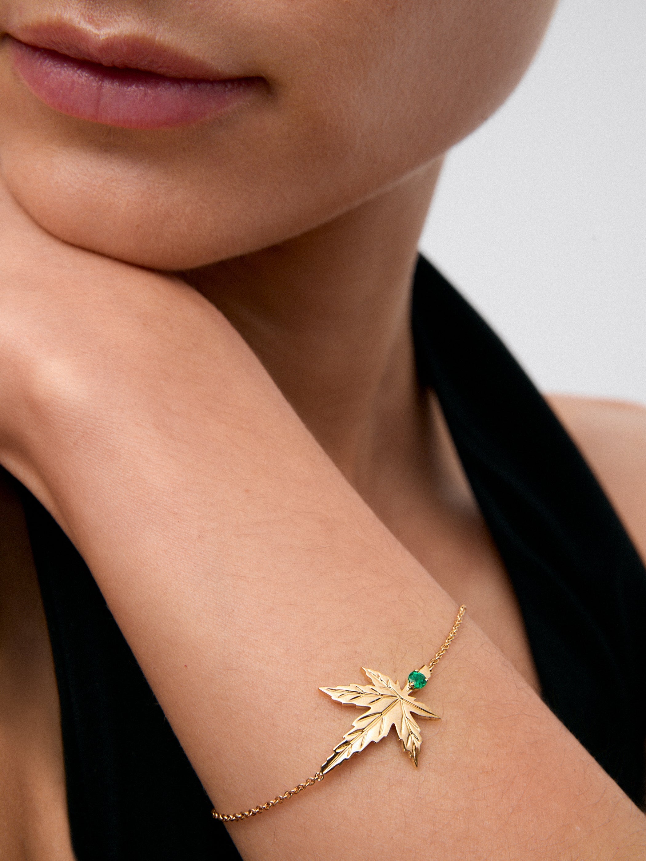 Pulsera de oro amarillo de 18K con una esmeralda en talla brillante de 0,11 cts y forma de hoja de arce