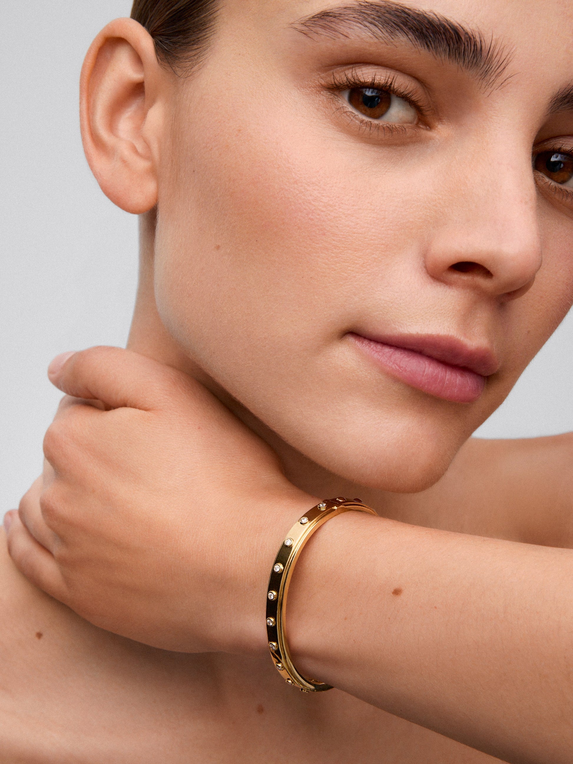 Pulsera rígida de oro amarillo de 18K con 11 diamantes en talla brillante con un total de 0,36 cts
