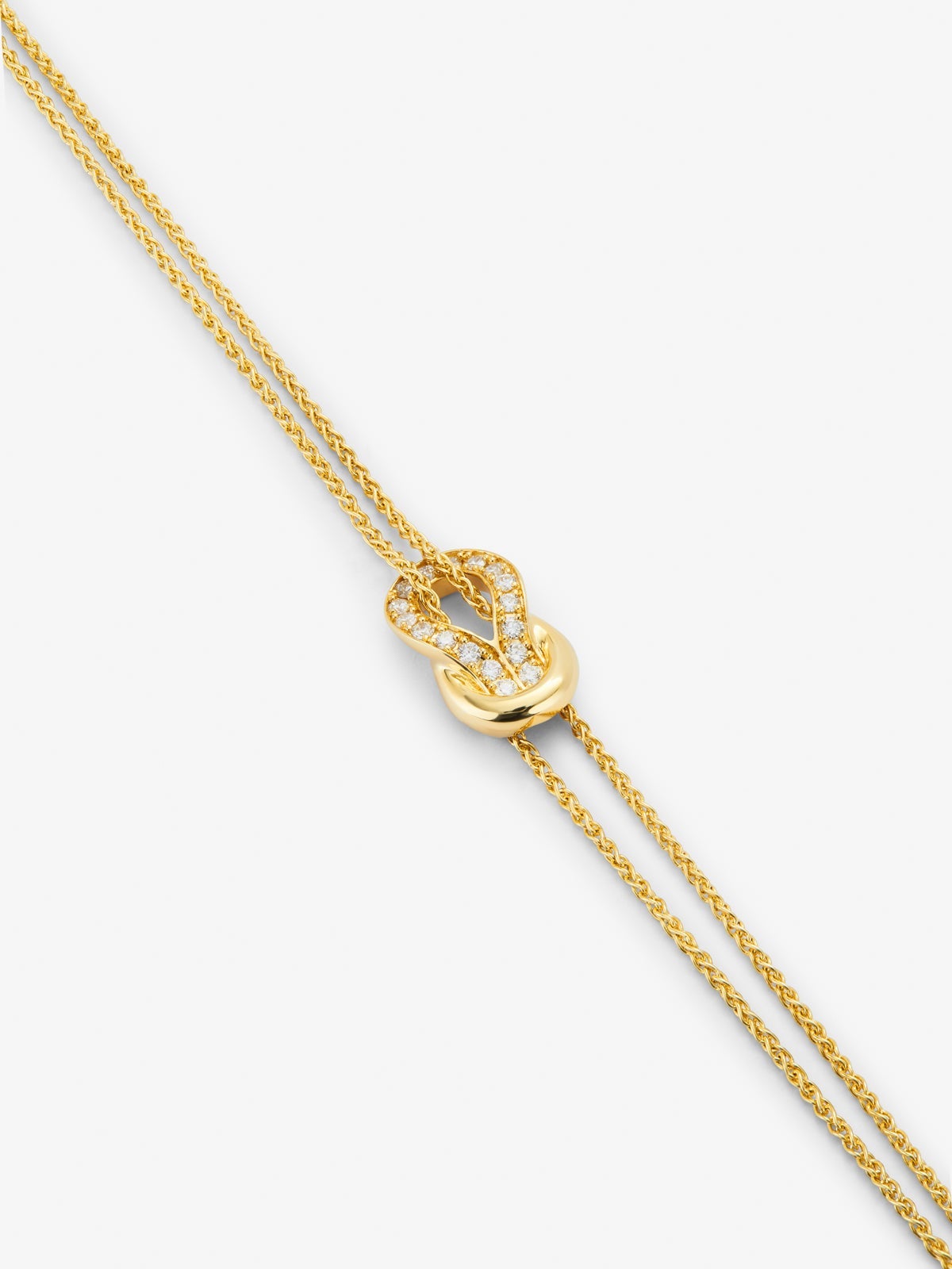 Pulsera de oro amarillo de 18K con 17 diamantes en talla brillante con un total de 0,15 cts y forma de nudo