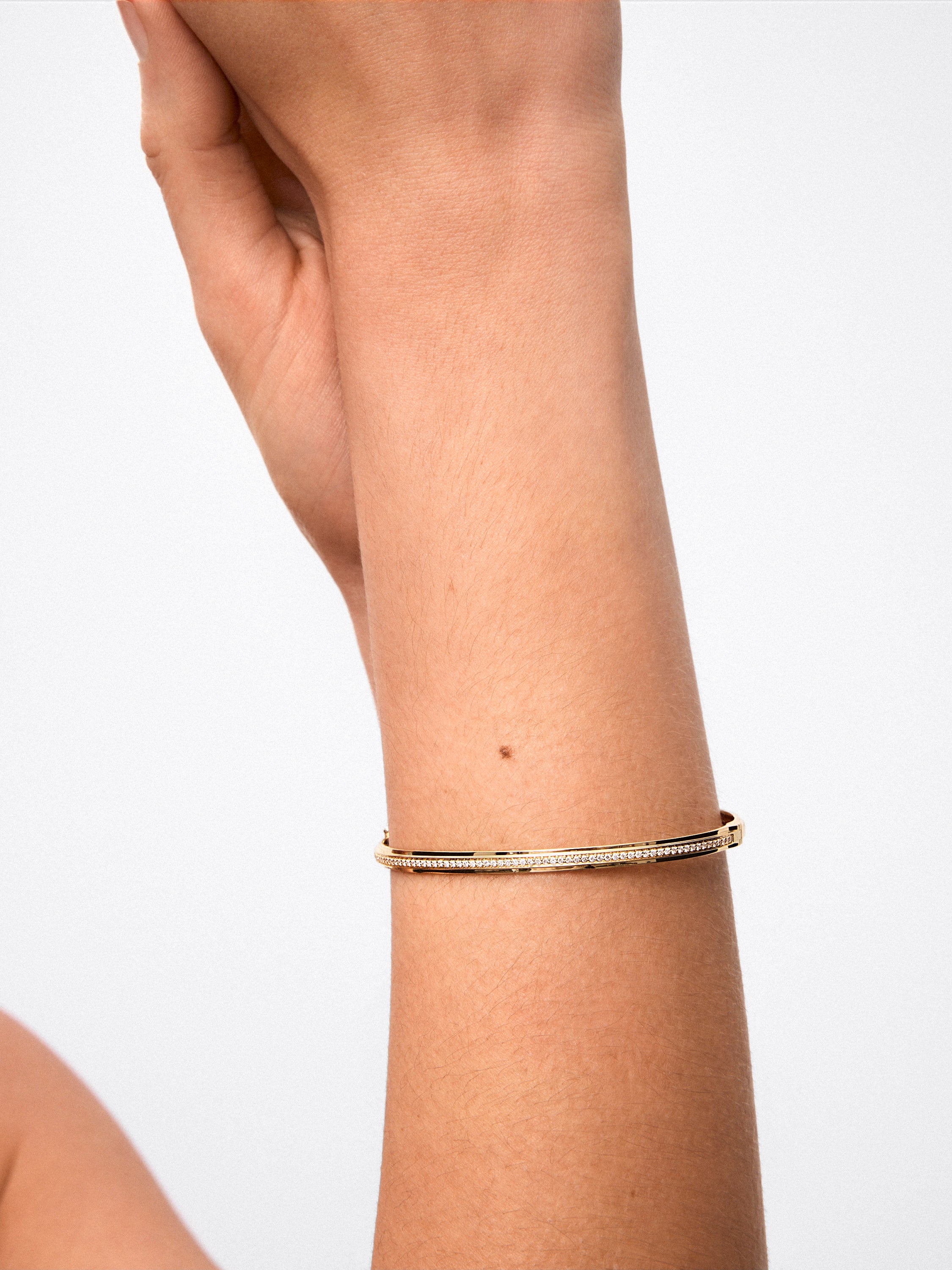 Pulsera rígida de oro amarillo de 18K con 64 diamantes en talla brillante con un total de 0,38 cts