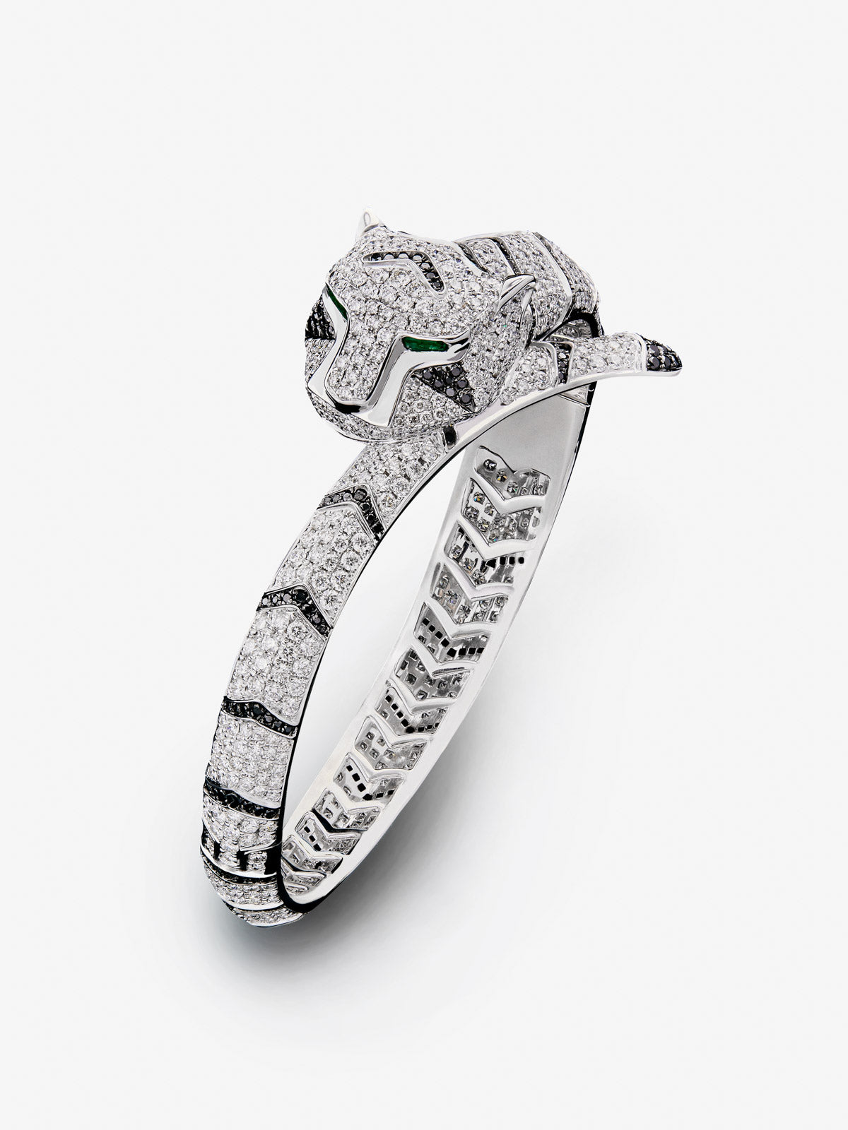 Rigid 18K white gold bracelet with 747 brilliant-cut white diamonds with a total of 8.17 cts, 241 brilliant-cut black diamonds with a total of 1.49 cts and 2 trapezoid-cut emeralds with a total of 0.13 tiger shaped cts