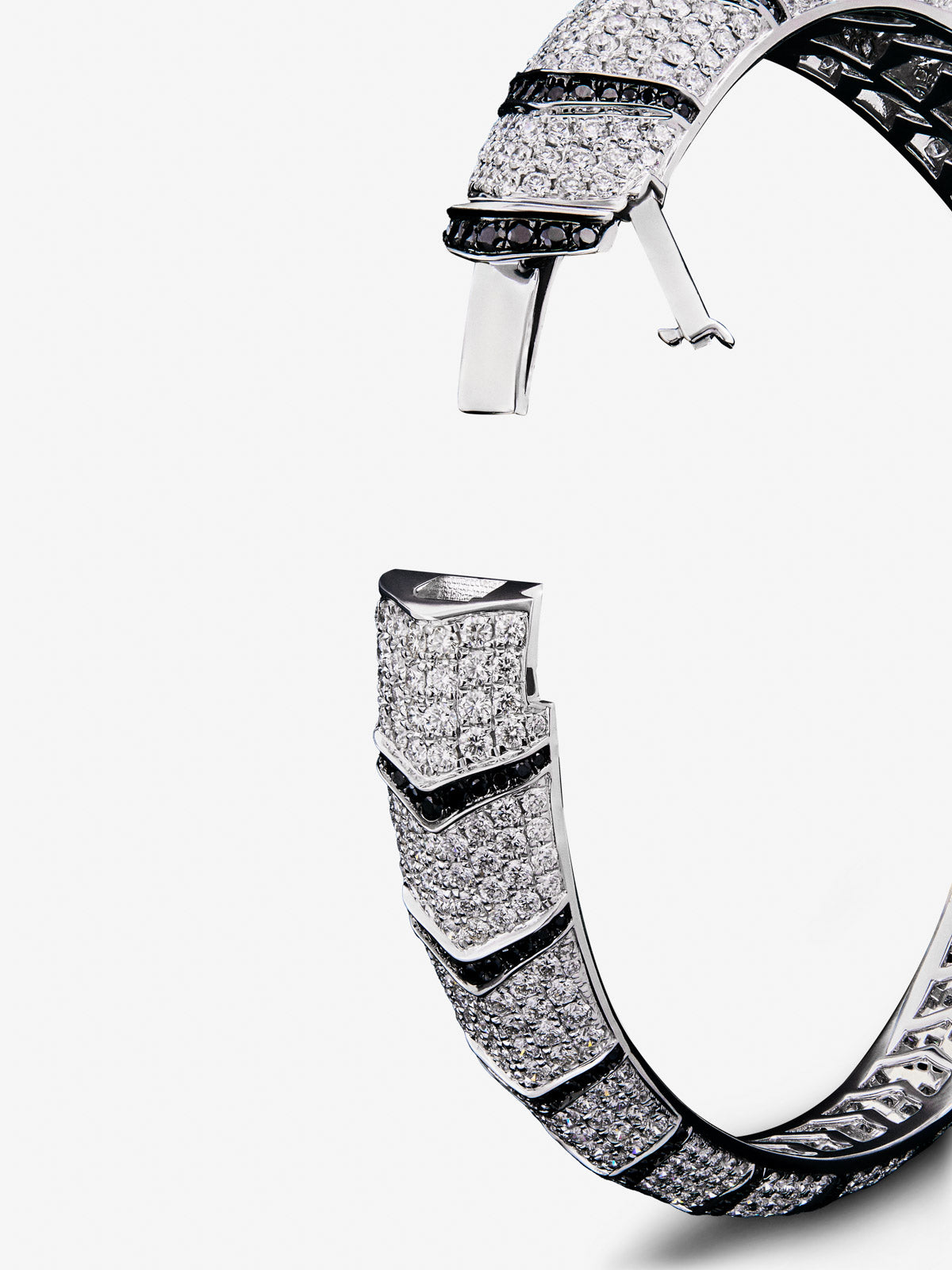 Rigid 18K white gold bracelet with 747 brilliant-cut white diamonds with a total of 8.17 cts, 241 brilliant-cut black diamonds with a total of 1.49 cts and 2 trapezoid-cut emeralds with a total of 0.13 tiger shaped cts