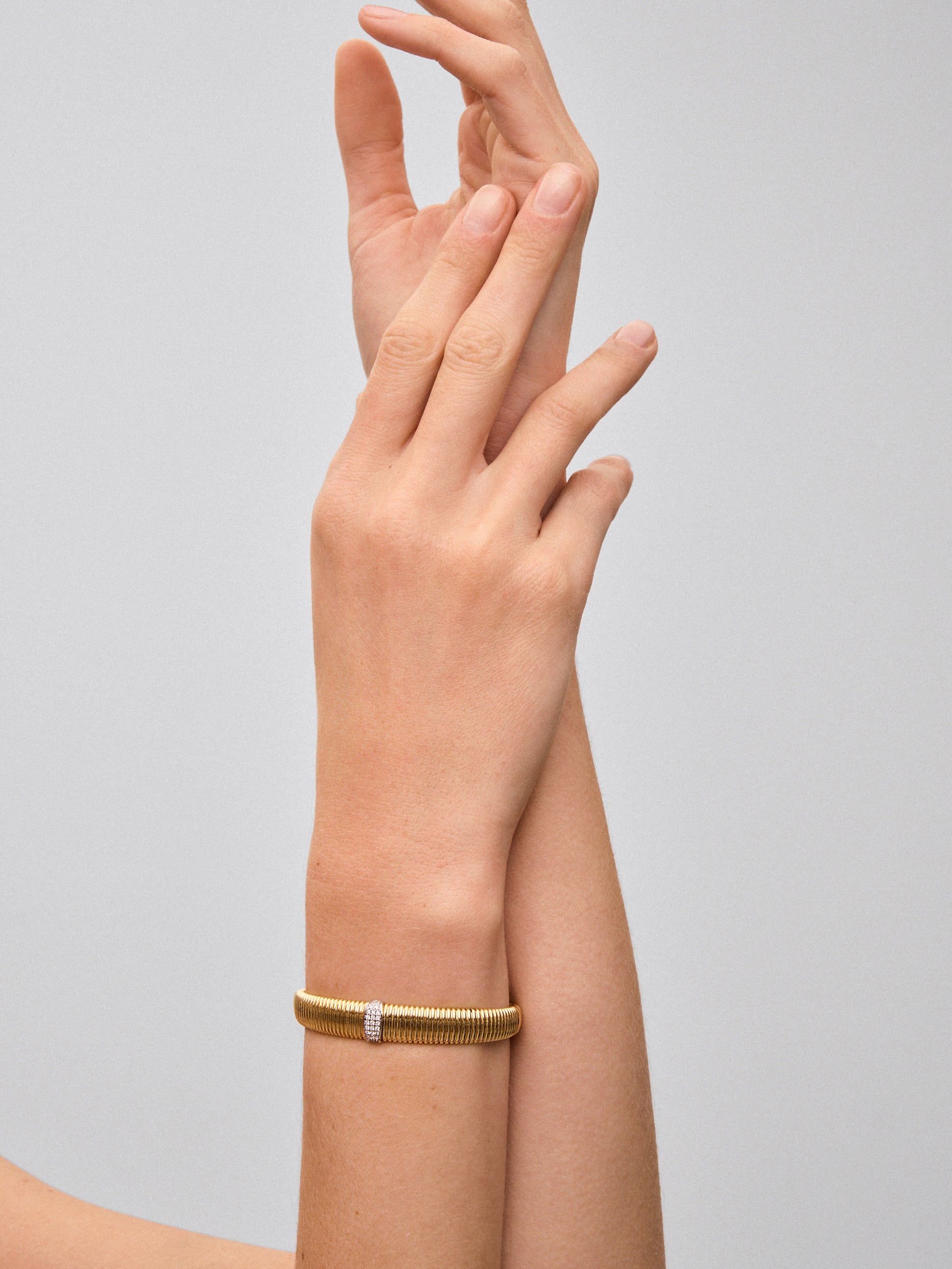 Pulsera rígida gallonada de oro blanco y amarillo de 18K con pavé de diamantes en talla brillante con un total de 0,16 cts