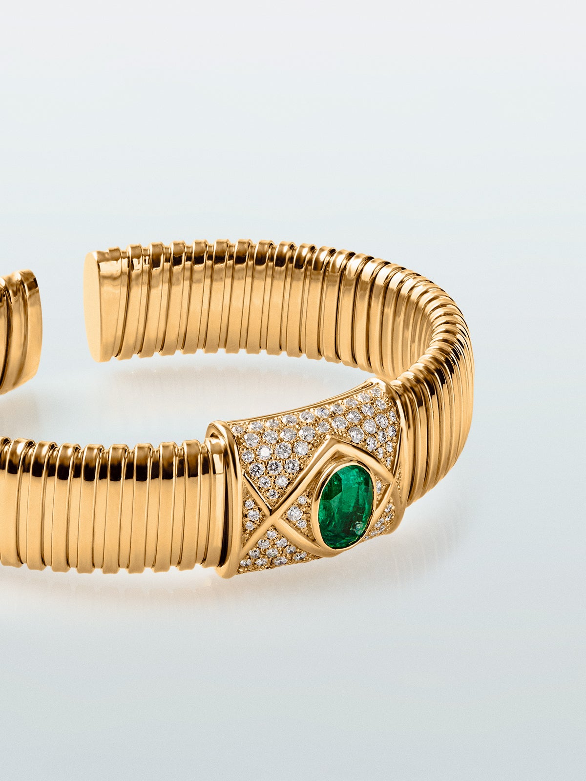 Pulsera tubogas de oro amarillo de 18K con esmeralda en talla oval de 2,01 cts y 80 diamantes en talla brillante con un total de 0,1 cts