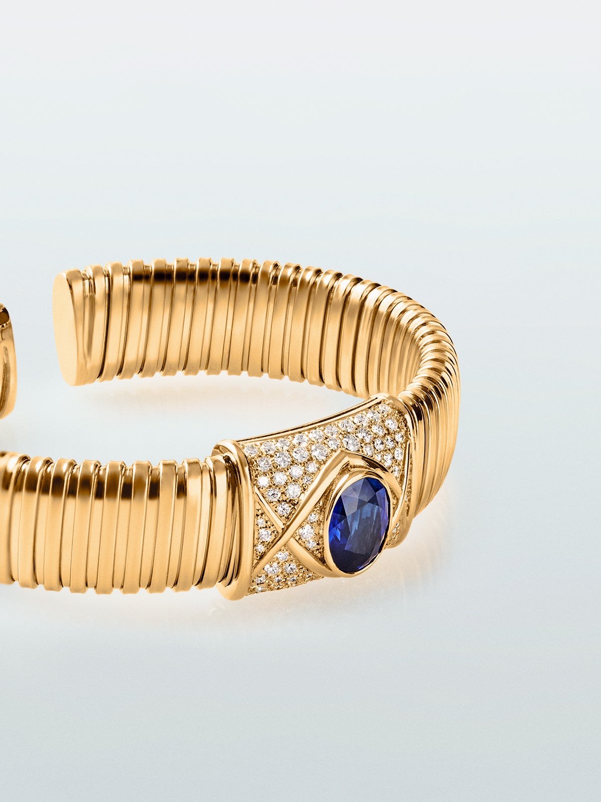 Pulsera tubogas de oro amarillo de 18K con zafiro azul royal en talla oval de 3,6 cts y 82 diamantes en talla brillante con un total de 0,1 cts