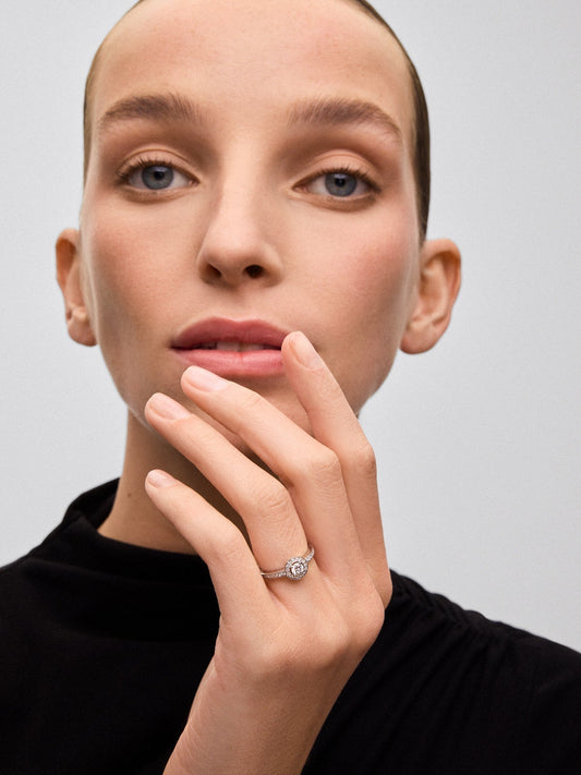 Anillo solitario de oro blanco de 18K con diamante central en talla brillante de 0,25 cts y 30 diamantes en talla brillante con un total de 0,24 cts