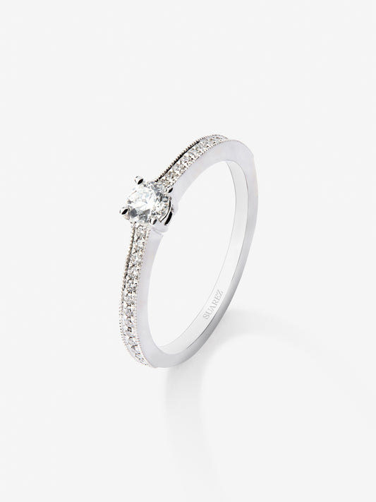 Anillo solitario de oro blanco de 18K con un diamante central en talla brillante de 0,23 cts y brazo de 29 diamantes en talla brillante con un total de 0,12 cts