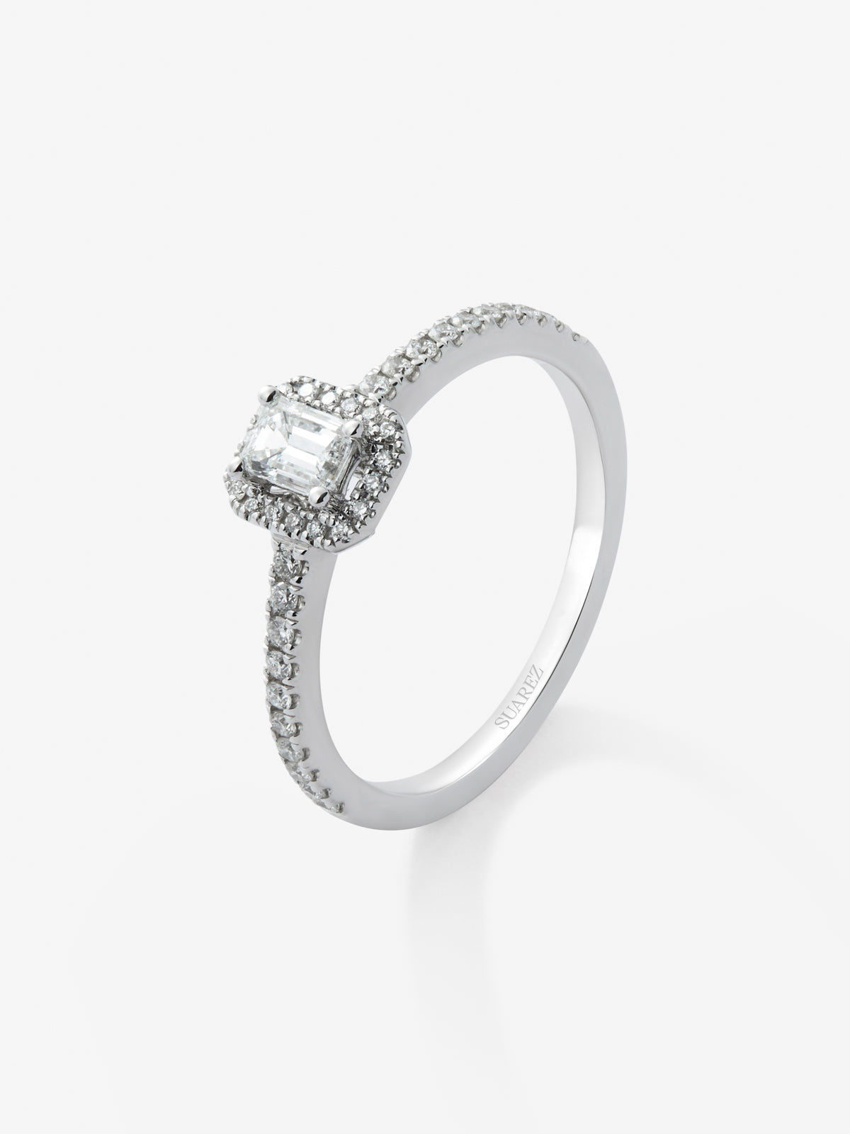 Anillo de oro blanco de 18K con diamante en talla esmeralda de 0,25 cts y orla de diamantes en talla brillante con un total de 0,19 cts