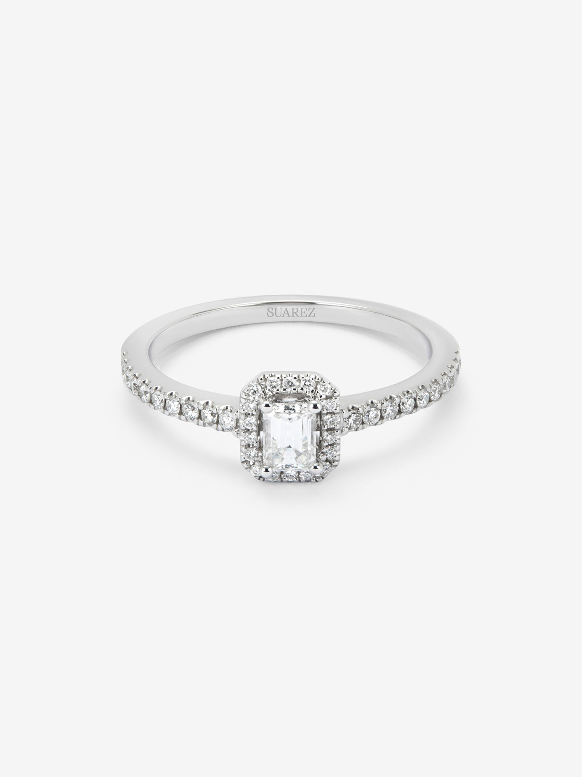 Anillo de oro blanco de 18K con diamante en talla esmeralda de 0,25 cts y orla de diamantes en talla brillante con un total de 0,19 cts