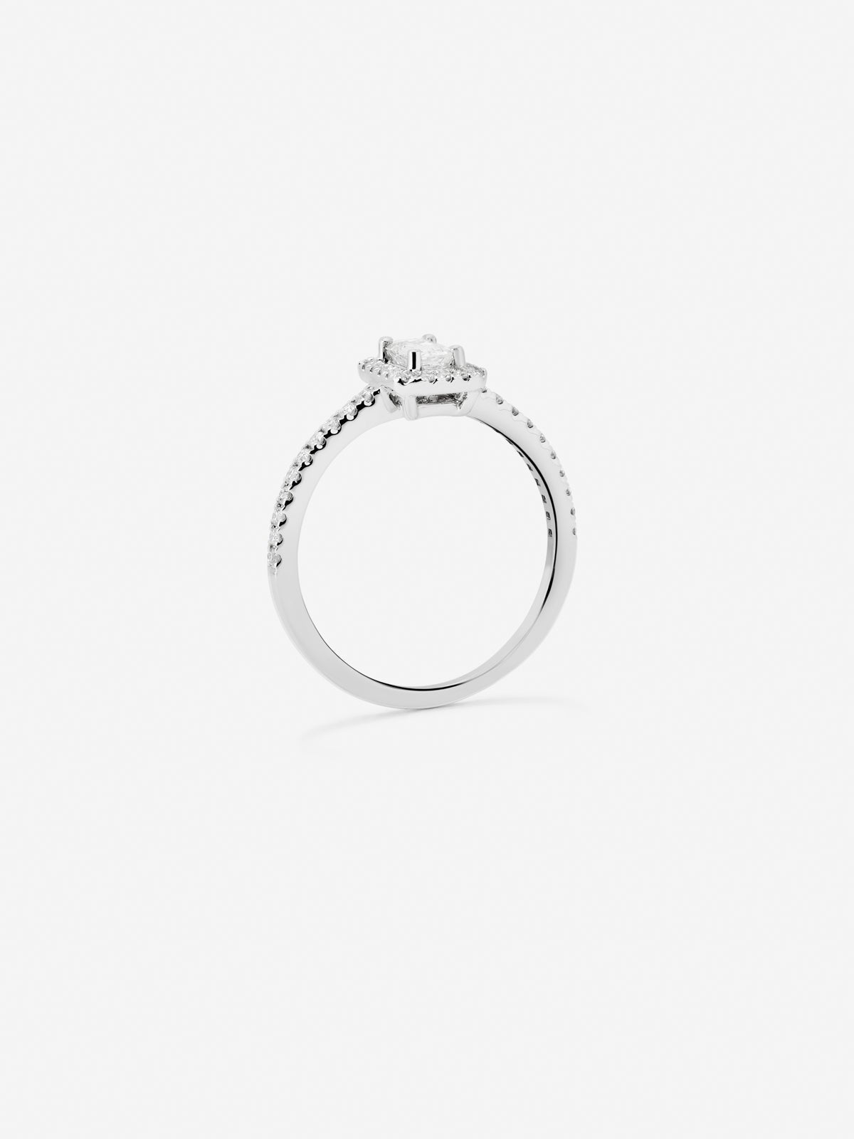 Anillo de oro blanco de 18K con diamante en talla esmeralda de 0,24 cts y orla de diamantes en talla brillante con un total de 0,17 cts