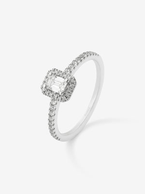 Anillo de oro blanco de 18K con diamante en talla esmeralda de 0,24 cts y orla de diamantes en talla brillante con un total de 0,17 cts